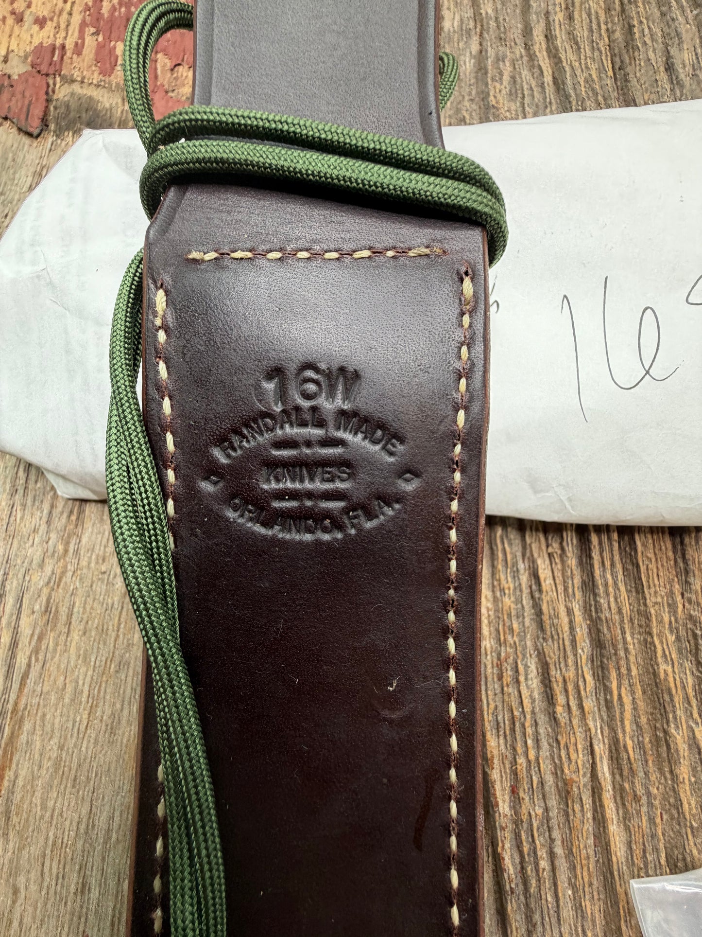 New in Paper Randall Model 16-7 Diver with a Black Micarta handle. SS blade, Brass hilt, Sawteeth, Lanyard, Brown leather waxed sheath.