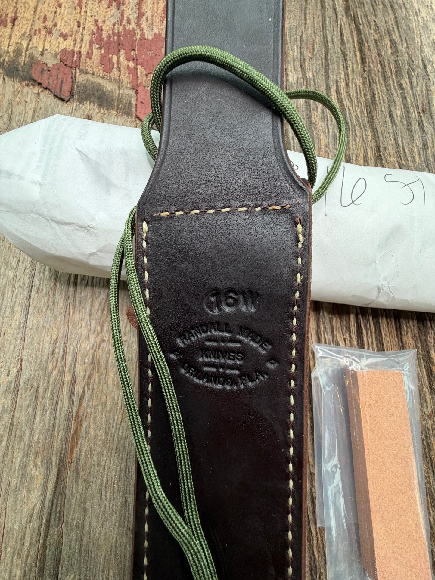New in Paper Randall Model 16-7 Diver with a Black Micarta handle, Single finger grip , SS blade, Brass hilt, Sawteeth, Lanyard, Brown leather waxed sheath.