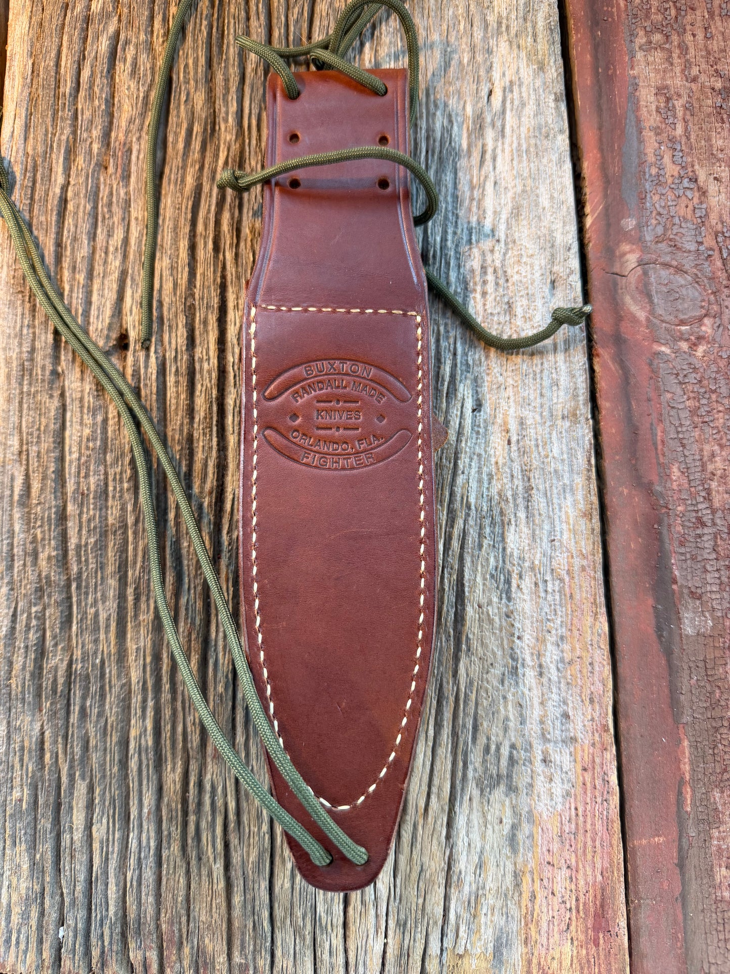Mint Randall by Gutcher Knife Sheath for a Model Buxton Fighter. Randall snaps, double stitched, pouch with stone, lanyards straps as well.