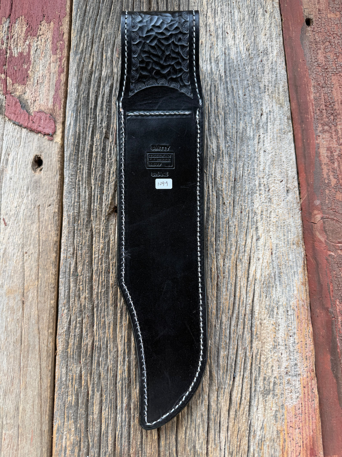 Randall Model Smithsonian sheath with a Western Diamondback RattleSnake skin inlay from Treeman Sheaths. Very dark skin, white thread deviated stitching, black canteen snap.