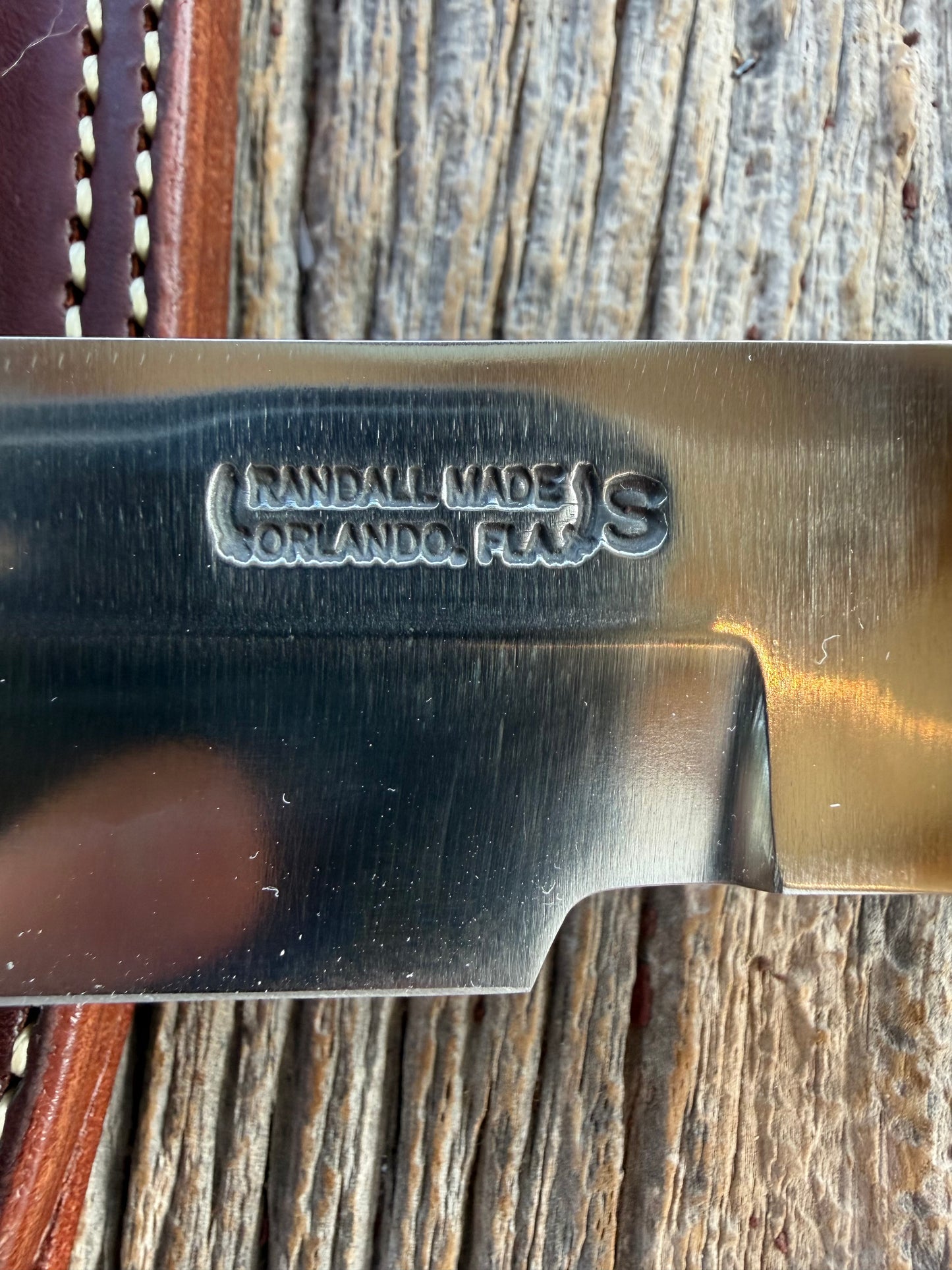 Randall Model 14-7.5 with a Black Micarta finger grooved handle. Stainless steel blade, Brass double hilt brown leather sheath.