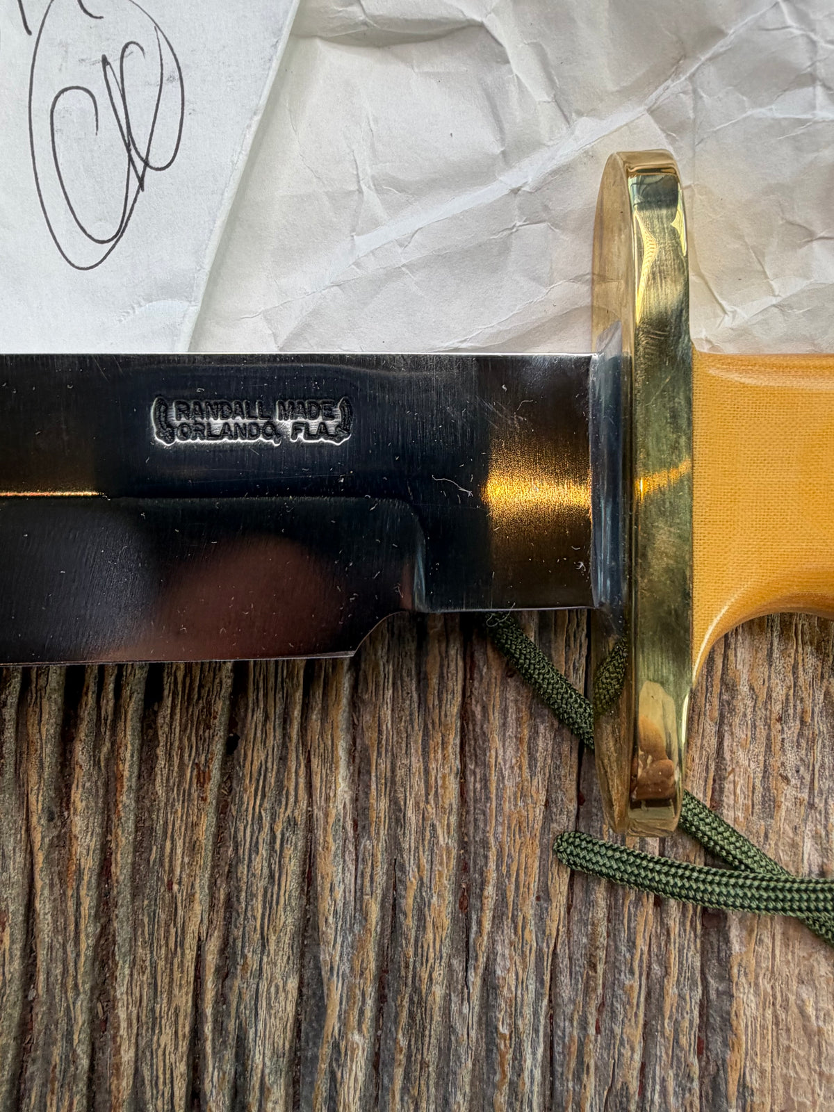 Randall Model 14-7.5 with a Yellow Micarta single finger handle. Carbon steel blade, brass double hilt, brown leather sheath, Lanyard.