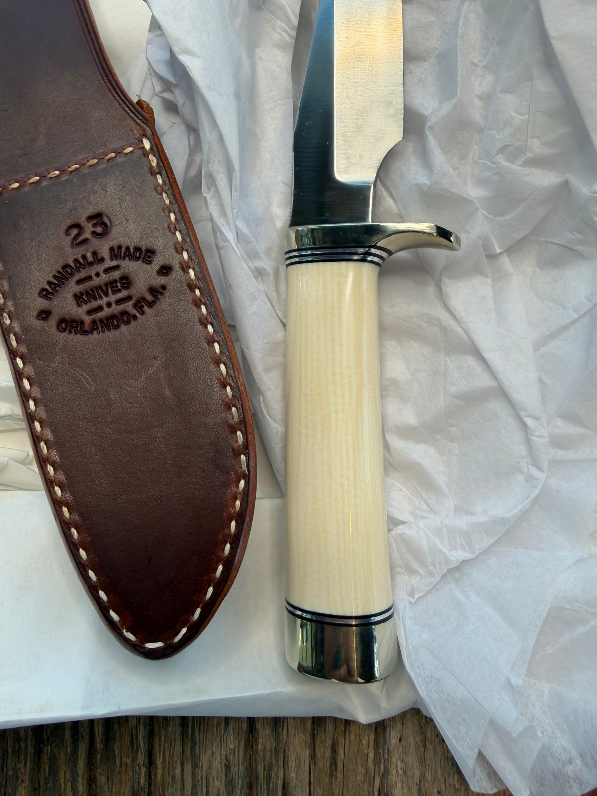 New in paper Randall Model 23 Game Master in dealer supplied Resin, Stainless steel blade, Nickel silver hilt and butt cap, Black and Aluminum spacers and Brown leather sheath.