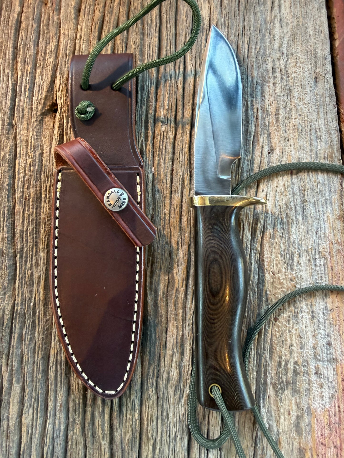 Nice Randall Model 28 Woodsman in Black Micarta. SS blade, brass single hilt. Lanyard. Brown leather sheath.