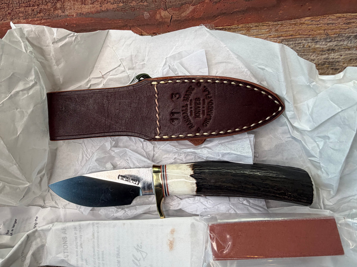 New in paper Randall Model 11-3 Alaskan Skinner in Stag with a natural end. Carbon steel blade, Brass Single hilt and Brown leather sheath.