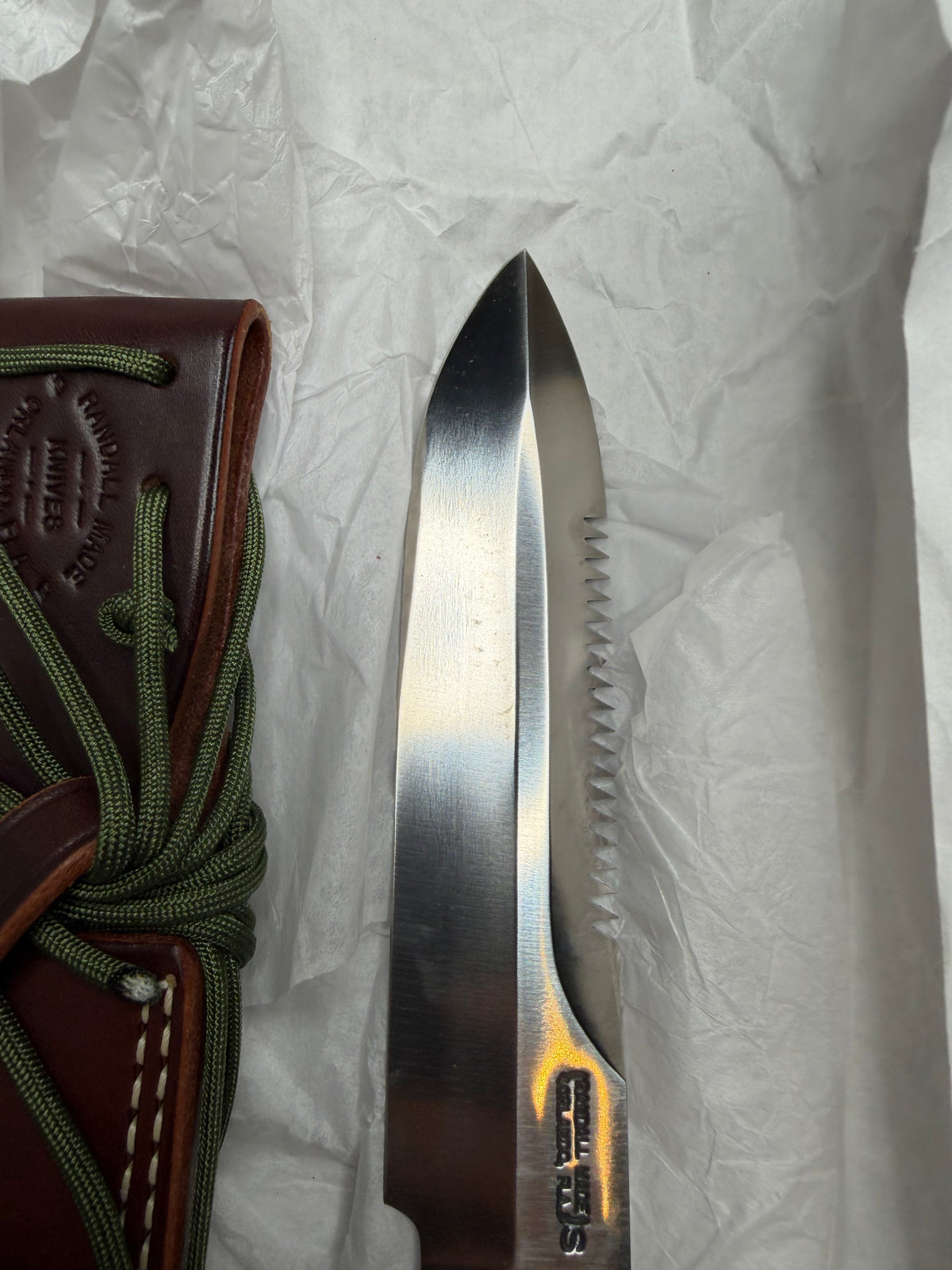 Randall Model 14-7.5 with a Black Micarta finger grooved handle. Stainless steel blade, Nickel double hilt brown leather sheath, Sawteeth, Lanyard.
