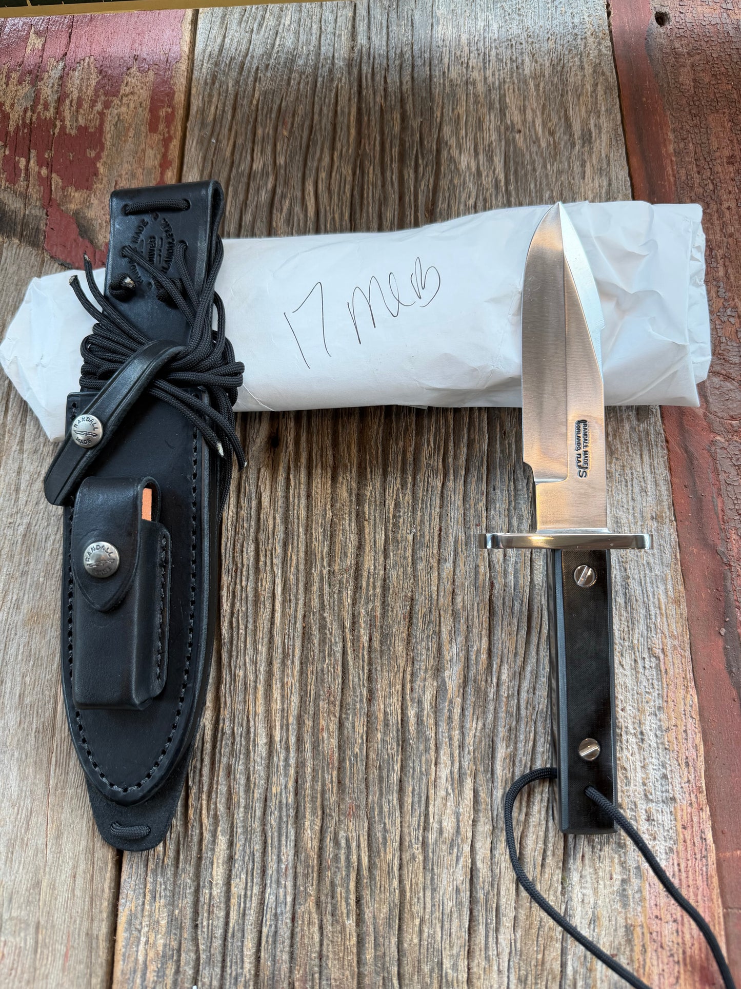 New in Paper Randall Model 17-5.5 Astro knife is a custom, handmade combat knife with a 5.5" stainless steel clip point blade and a brown leather sheath. Full tang design, black handle.