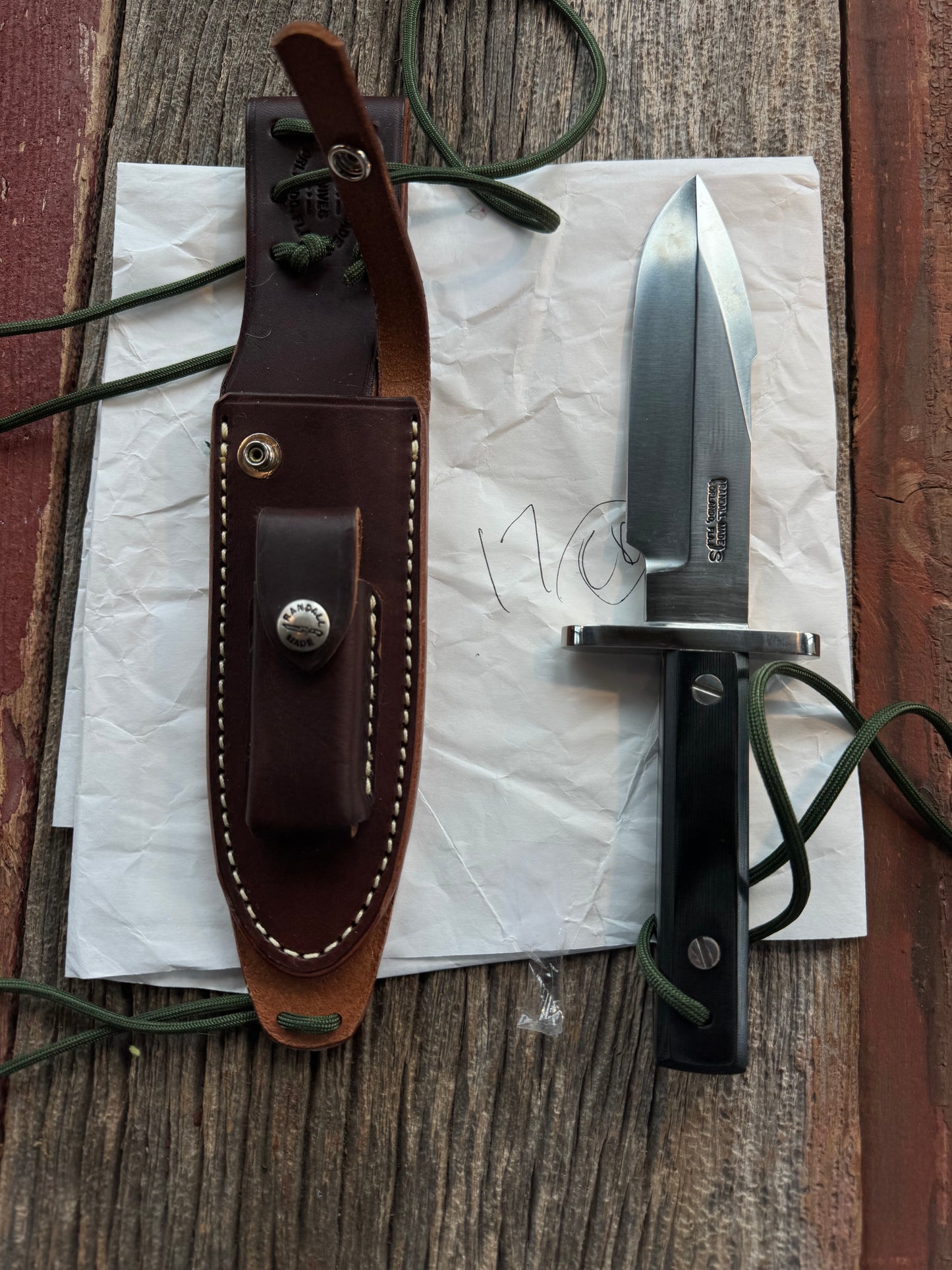New in Paper Randall Model 17-5.5 Astro knife is a custom, handmade combat knife with a 5.5" stainless steel clip point blade and a brown leather sheath. Full tang design, black handle.