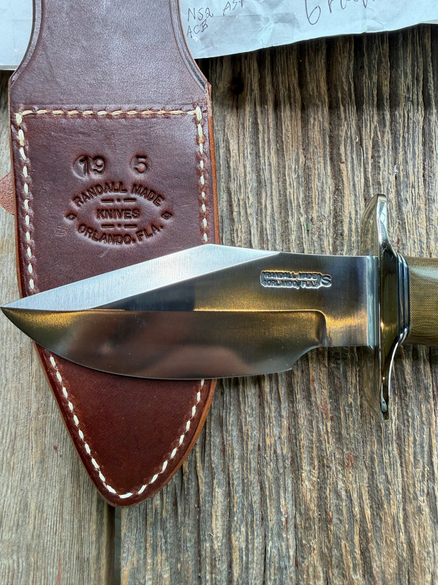 New in Paper Randall Model 19-5 Bushmaster with a Green Micarta handle. Stainless steel blade, Nickel silver hilt. Brown leather sheath. Crows Beak Aluminum handle.