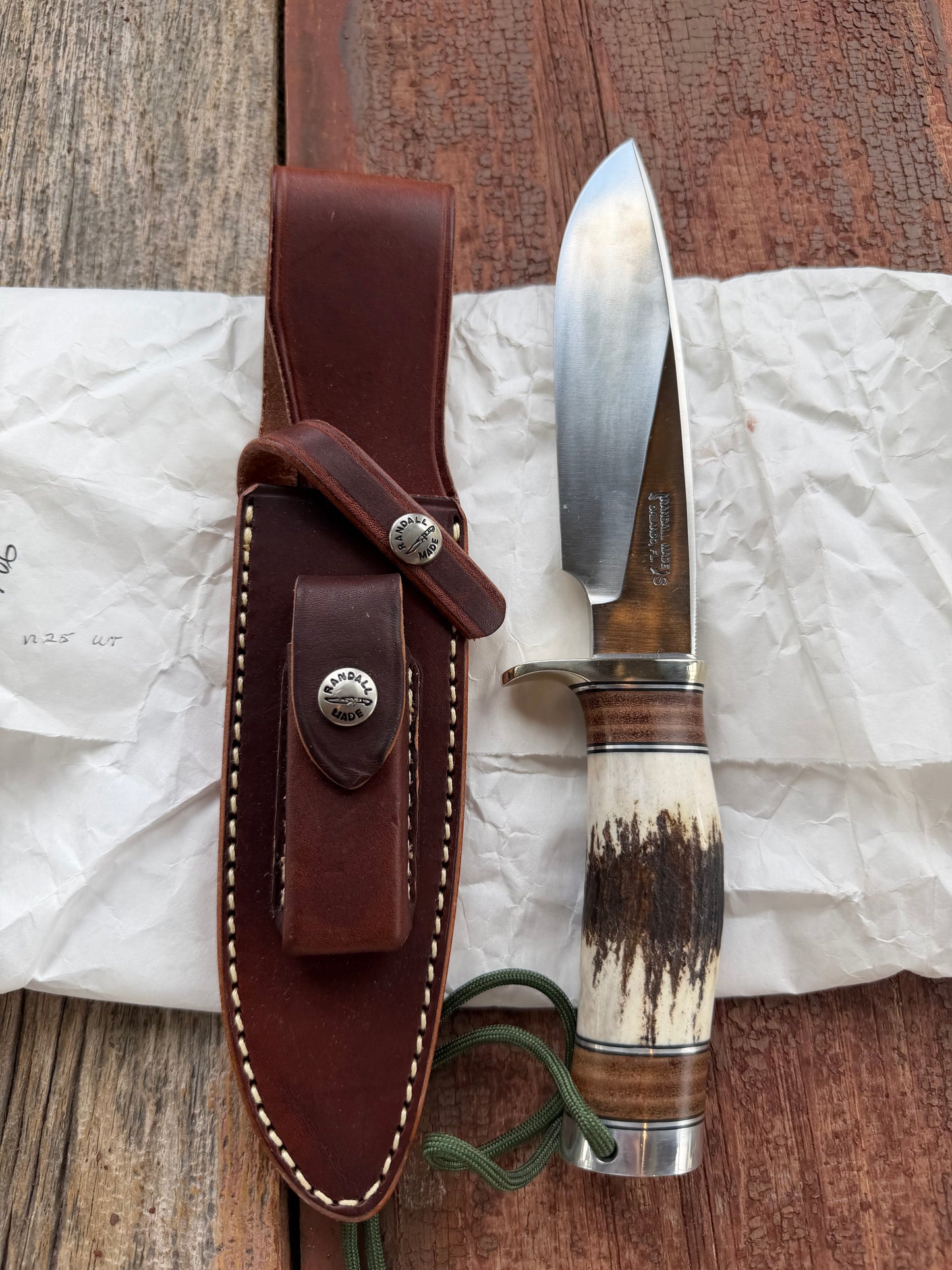 New in paper Randall Knife Model 25-6 Trapper in Stag Leather Handle Stainless Blade, nickel silver hilt , wrist thong.