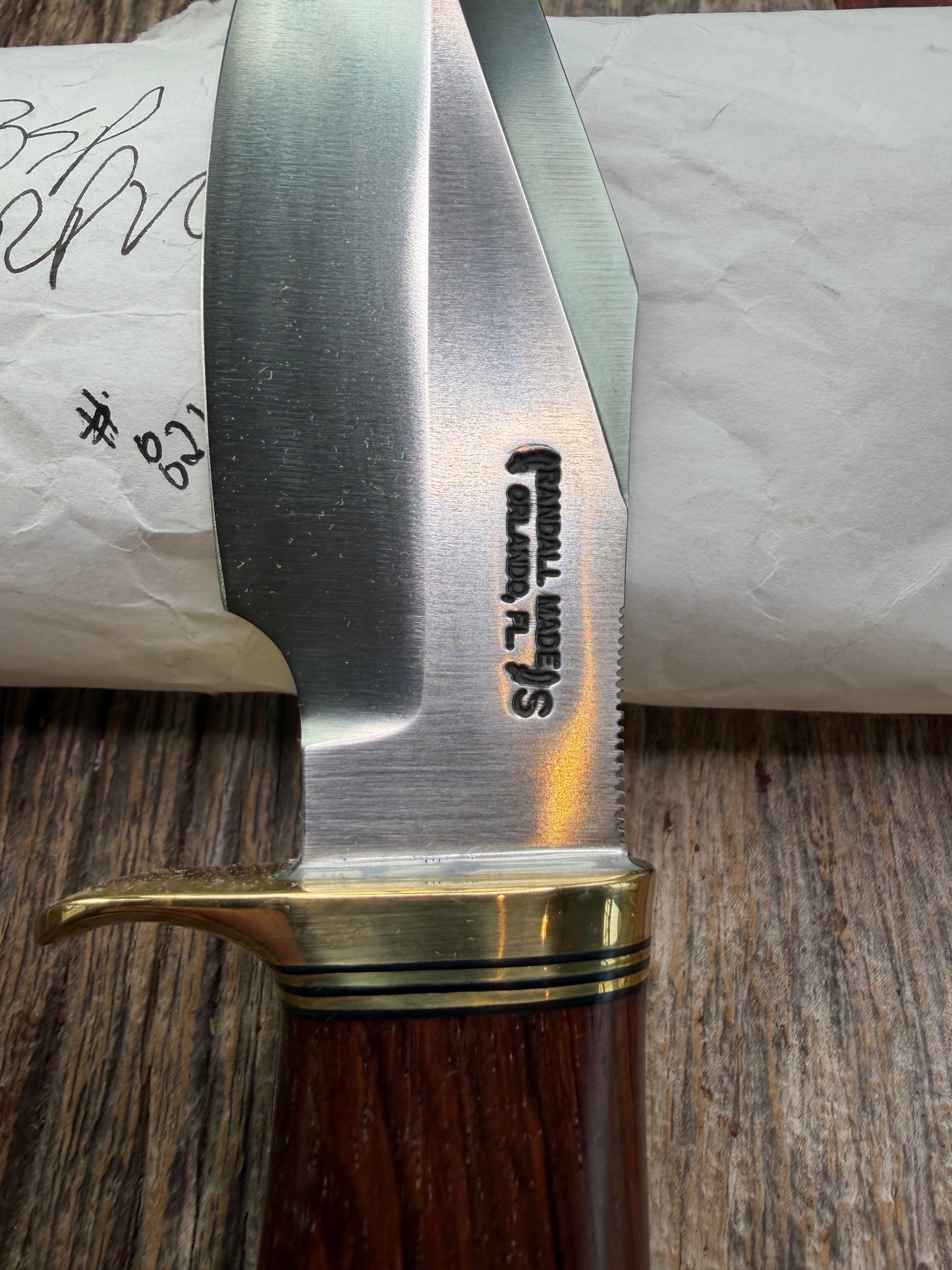New in Paper Randall Model 19-5 with a really nice grainy piece of Ironwood. brass single Hilt , Stainless steel, Lanyard and Brass plate.