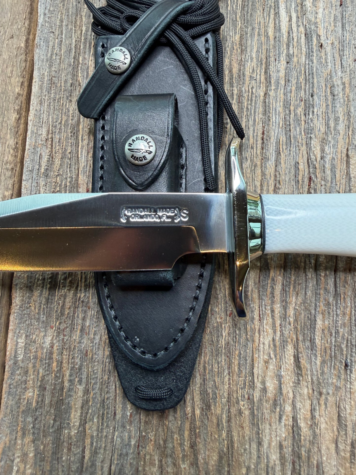 Randall Model 15 with a White Ivorite handle. Stainless steel blade, Nickel silver hilt and collar. Upgraded Black leather sheath.  Roundsd Aluminum butt cap.