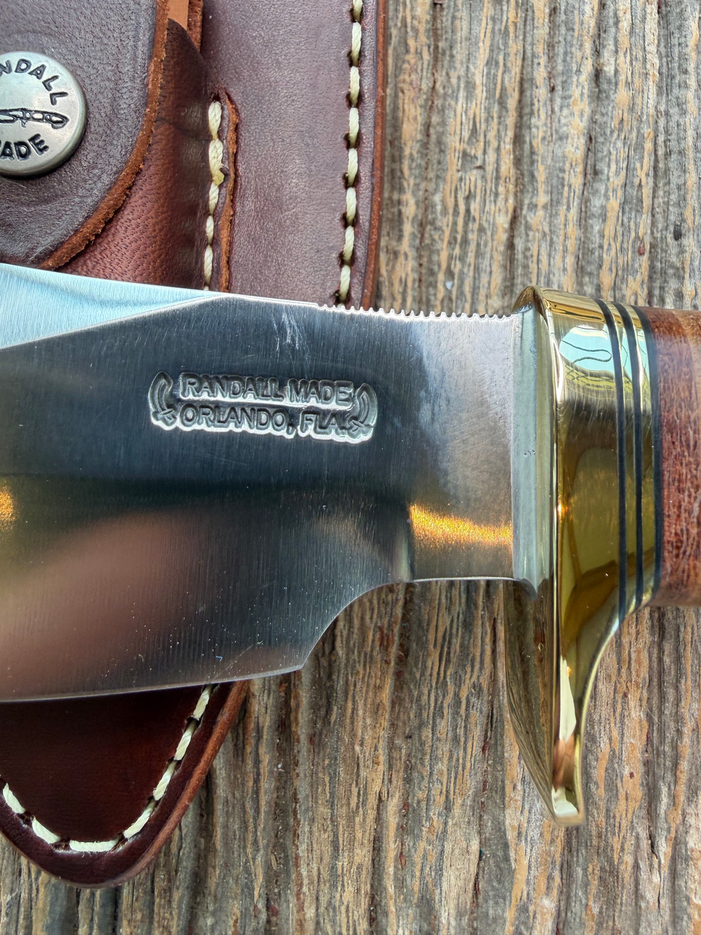 New Randall Model 19-5 Bushmaster with a Leather handle. Carbon blade, Brass single hilt. Brown leather sheath.