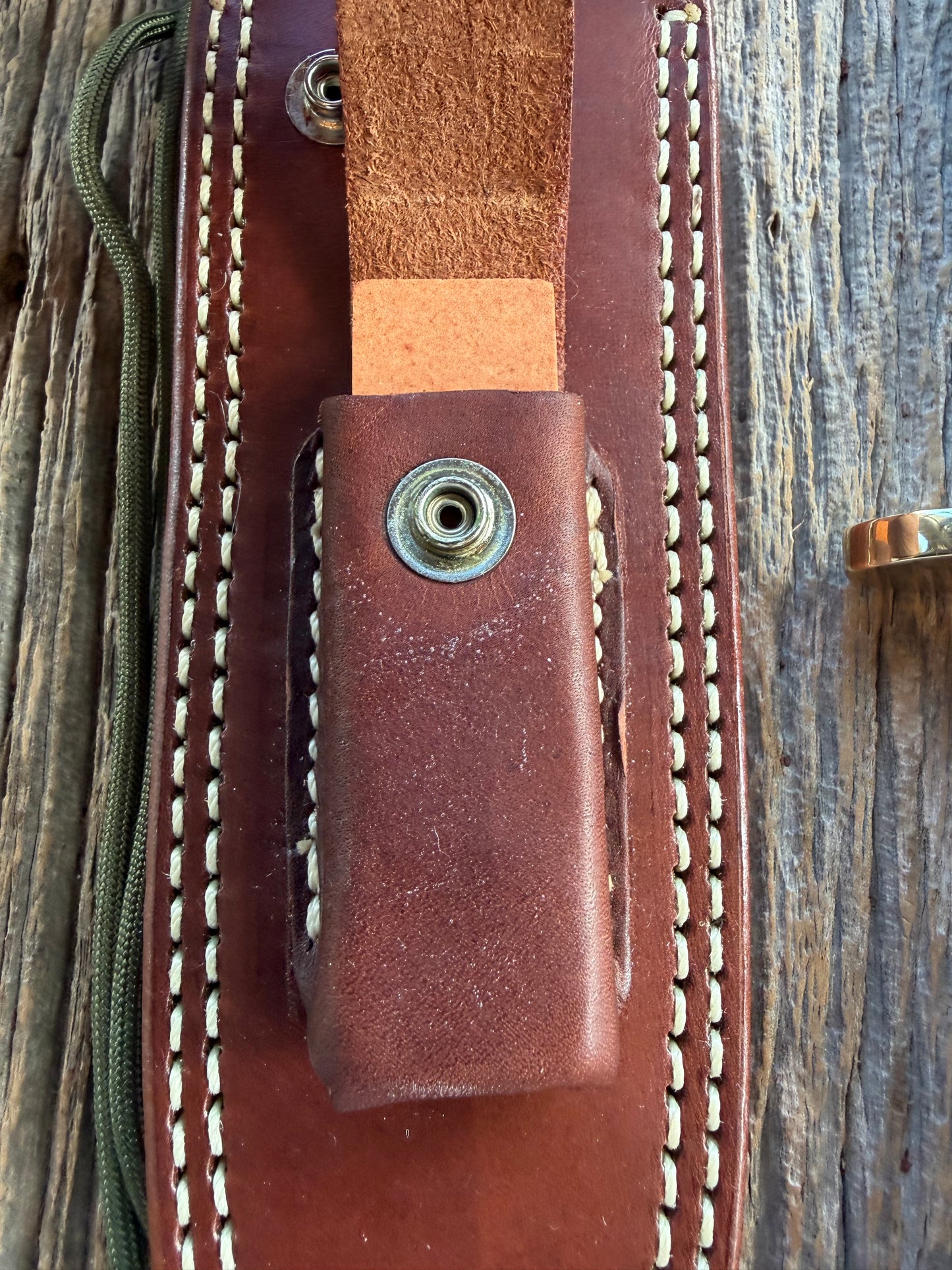Randall Model 14-7.5 with a Black Micarta finger grooved handle. Carbon steel blade, Brass double hilt brown leather sheath.