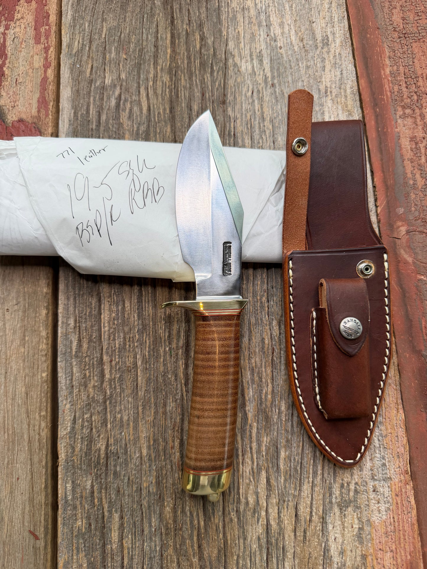 New in Paper Randall Model 19-5 Bushmaster with a Leather handle. Carbon blade, Brass single hilt. Brown leather sheath.
