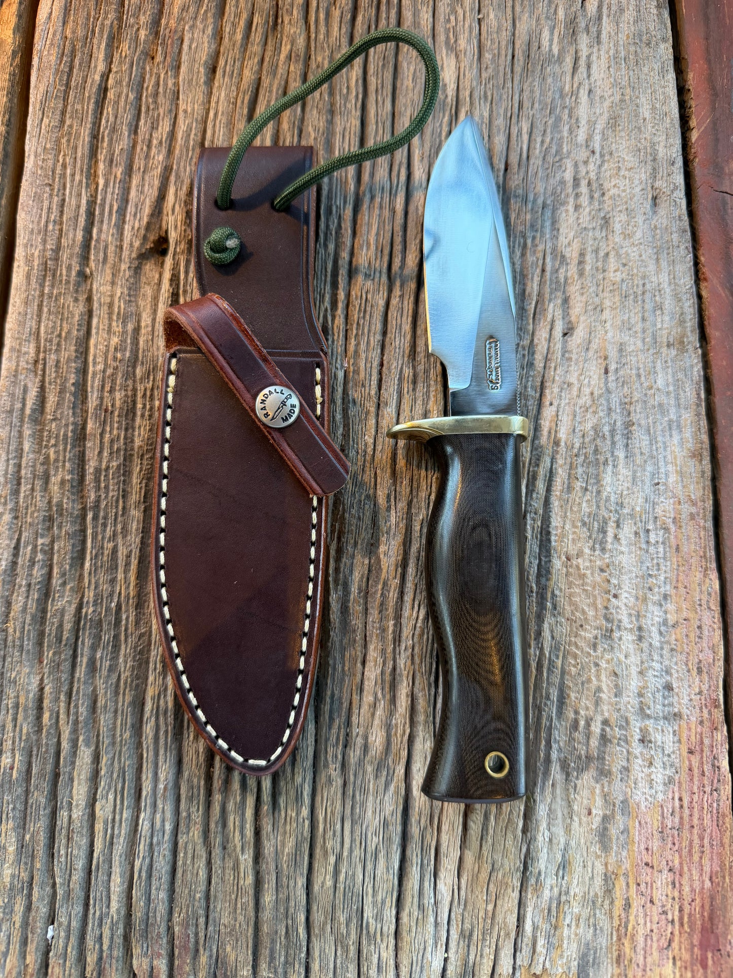 Nice Randall Model 28 Woodsman in Black Micarta. SS blade, brass single hilt. Lanyard. Brown leather sheath.