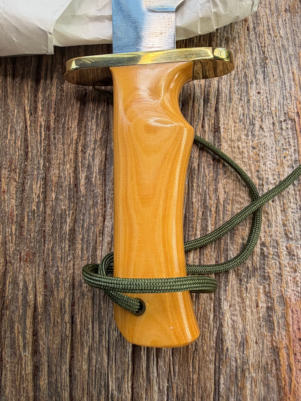Randall Model 14-7.5 with a Yellow Micarta single finger handle. Carbon steel blade, brass double hilt, brown leather sheath, Lanyard.