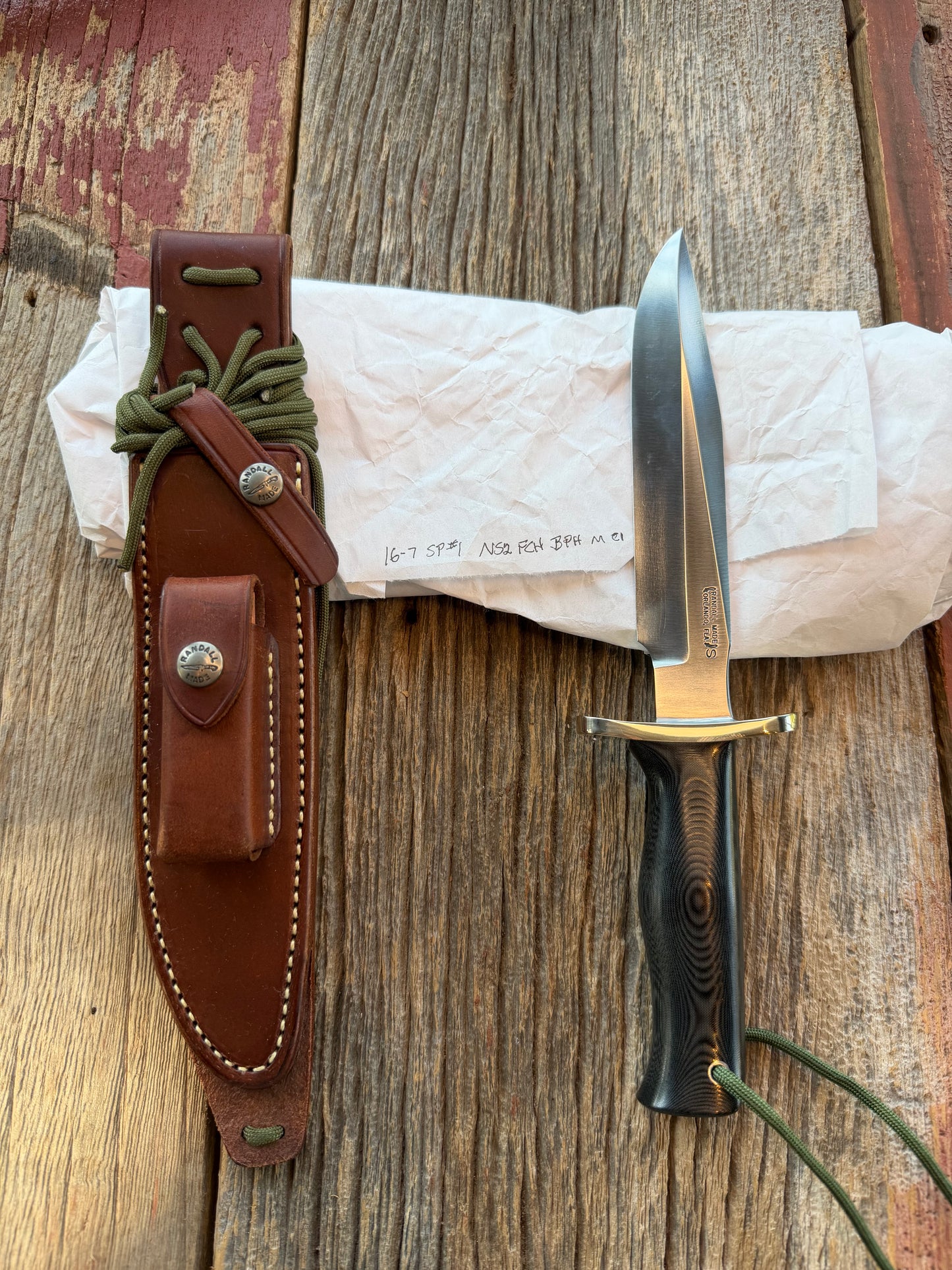 New in Paper Randall Model 16 SP#1 Special fighter with a Black Micarta handle. SS blade, Nickel silver Forward Curved hilt. Lanyard. Brown leather sheath.