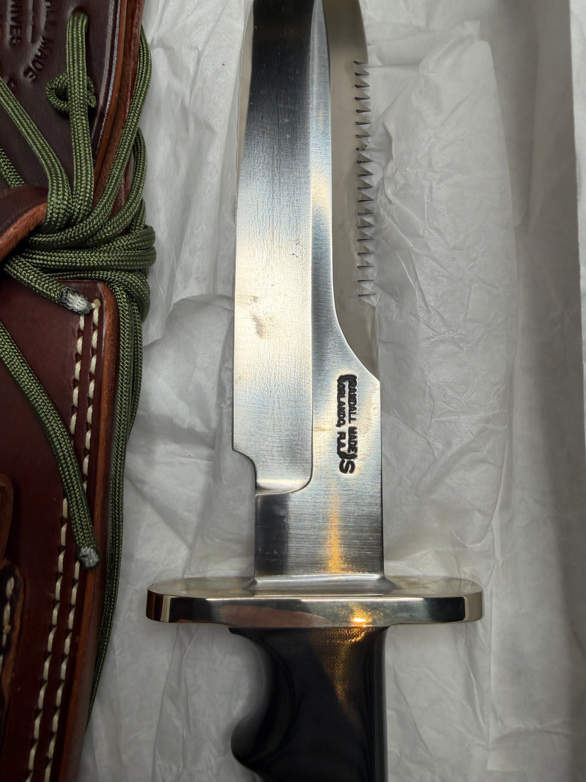 Randall Model 14-7.5 with a Black Micarta finger grooved handle. Stainless steel blade, Nickel double hilt brown leather sheath, Sawteeth, Lanyard.