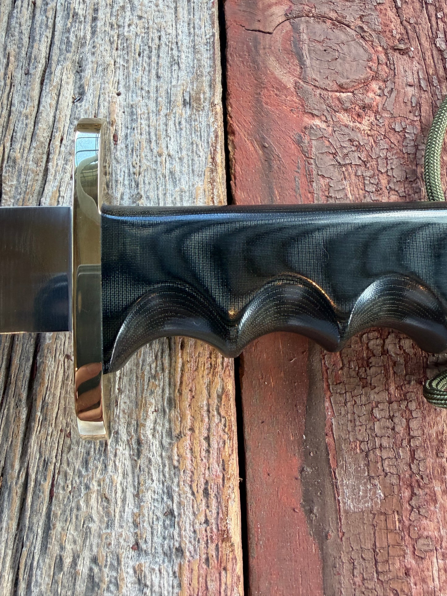 Randall Model 14-7.5 with a Black Micarta finger grooved handle. Carbon steel blade, Brass double hilt brown leather sheath.
