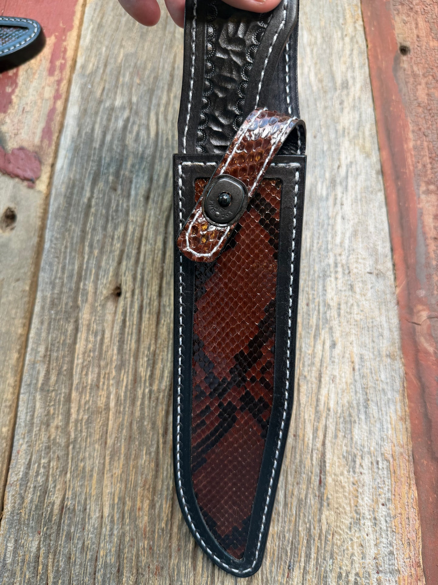 New Randall Model 1-8 Sheath in Exotic Brown Python Snake skin on black leather from Treeman with a black Canteen snap. Hand tooled belt loop. Deviated white stitching. Killer sheath.