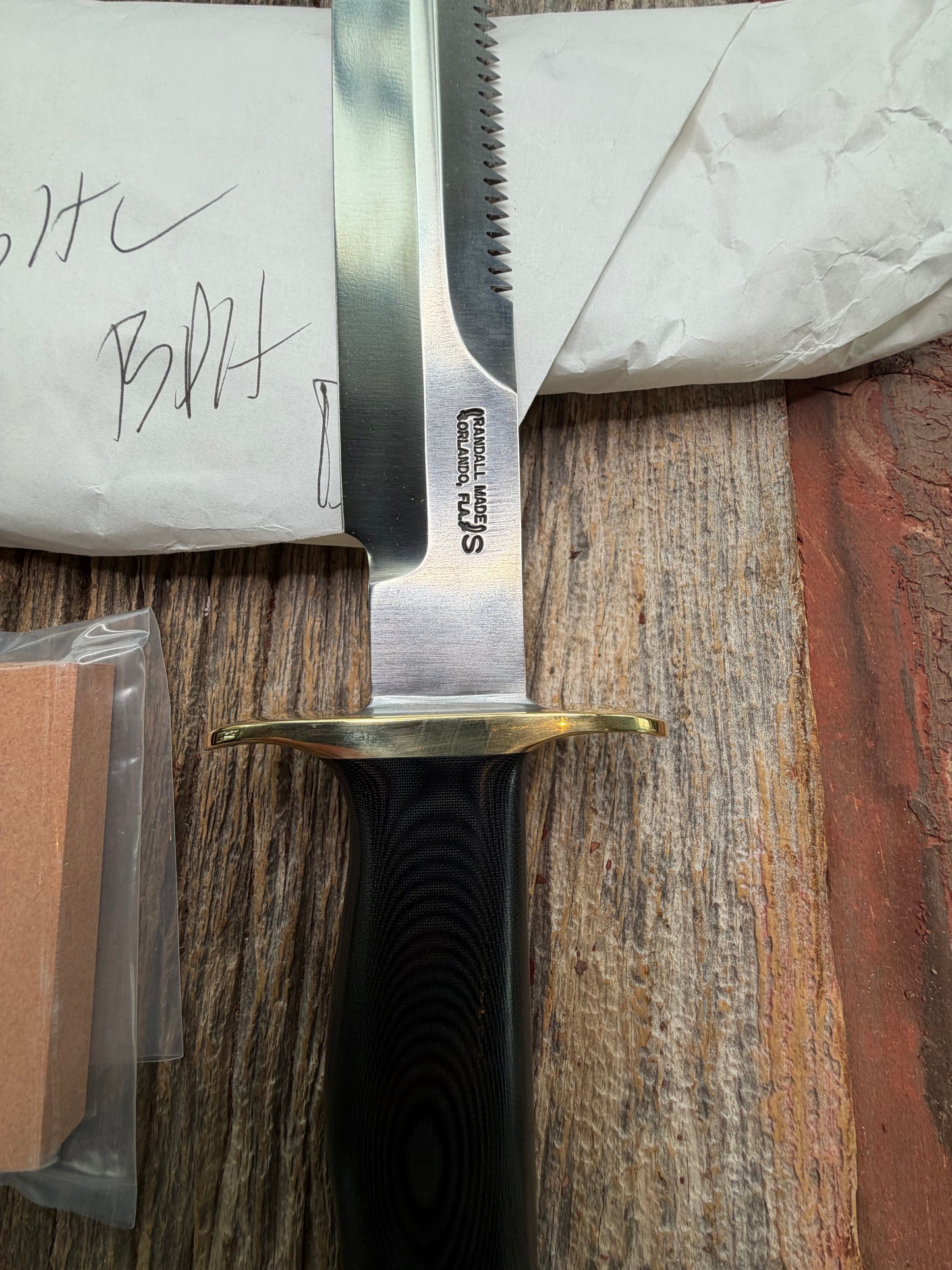 New in Paper Randall Model 16-7 Diver with a Black Micarta handle. SS blade, Brass hilt, Sawteeth, Lanyard, Brown leather waxed sheath.