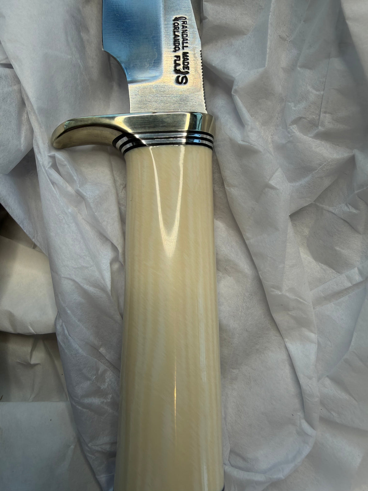 New in paper Randall Model 23 Game Master in dealer supplied Resin, Stainless steel blade, Nickel silver hilt and butt cap, Black and Aluminum spacers and Brown leather sheath.