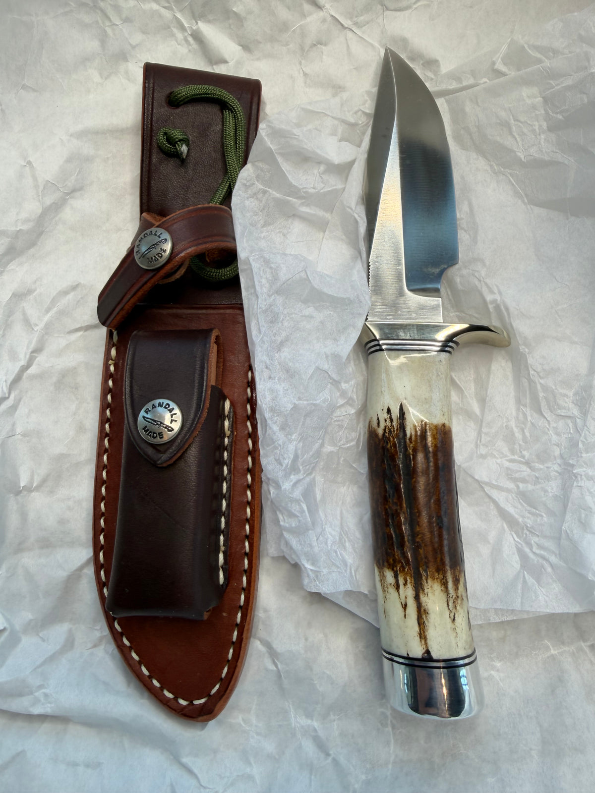 New in paper Randall Model 23 Game Master in a nice fat piece of Stag. Stainless steel blade, Nickel silver hilt, Black and Aluminum spacers and Brown leather sheath.