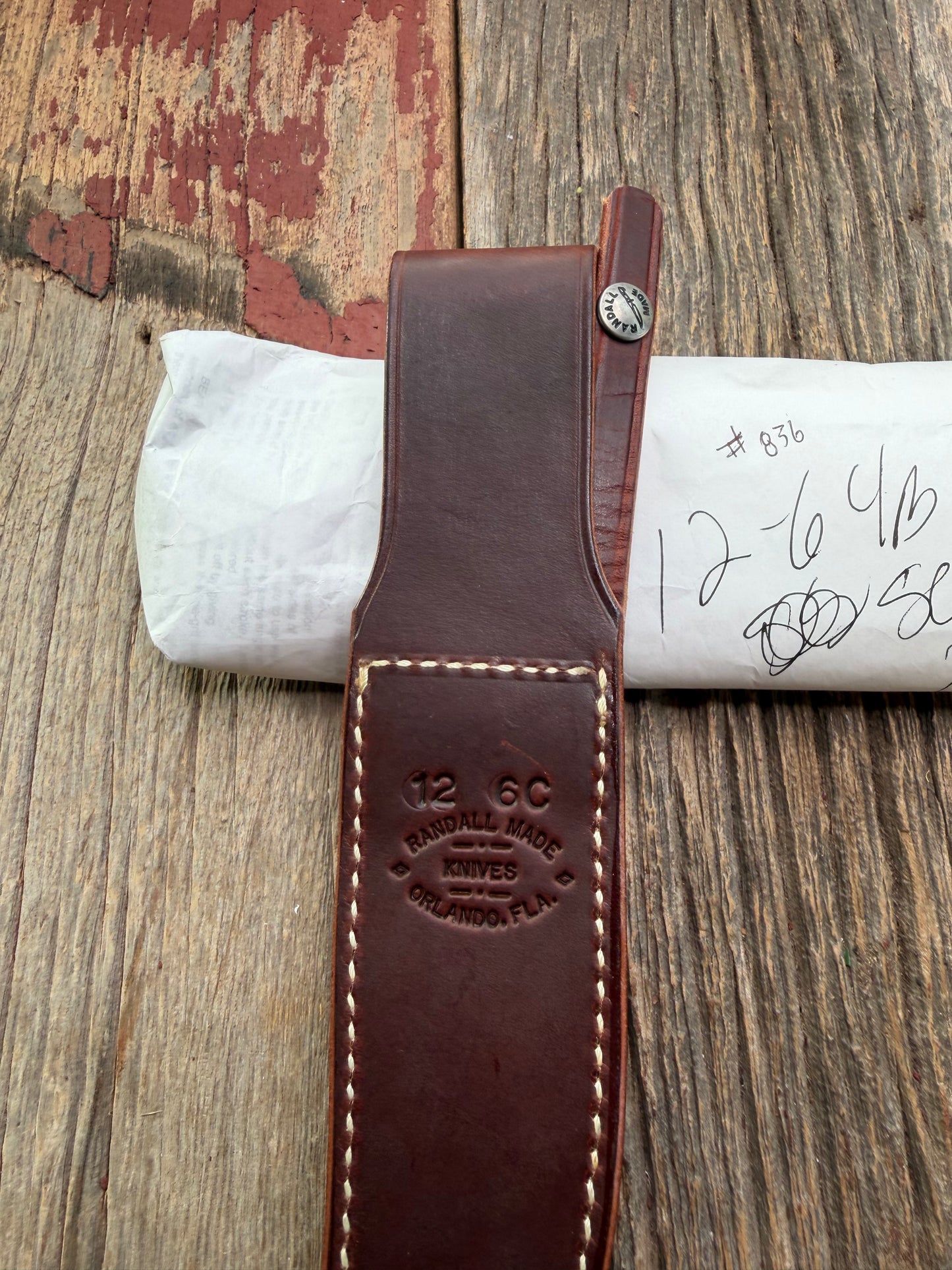 New in Paper Randall Model 12-6 Little Bear with a Maroon Micarta handle. Brass Hilt  and Brass collar Carbon steel, natural end.