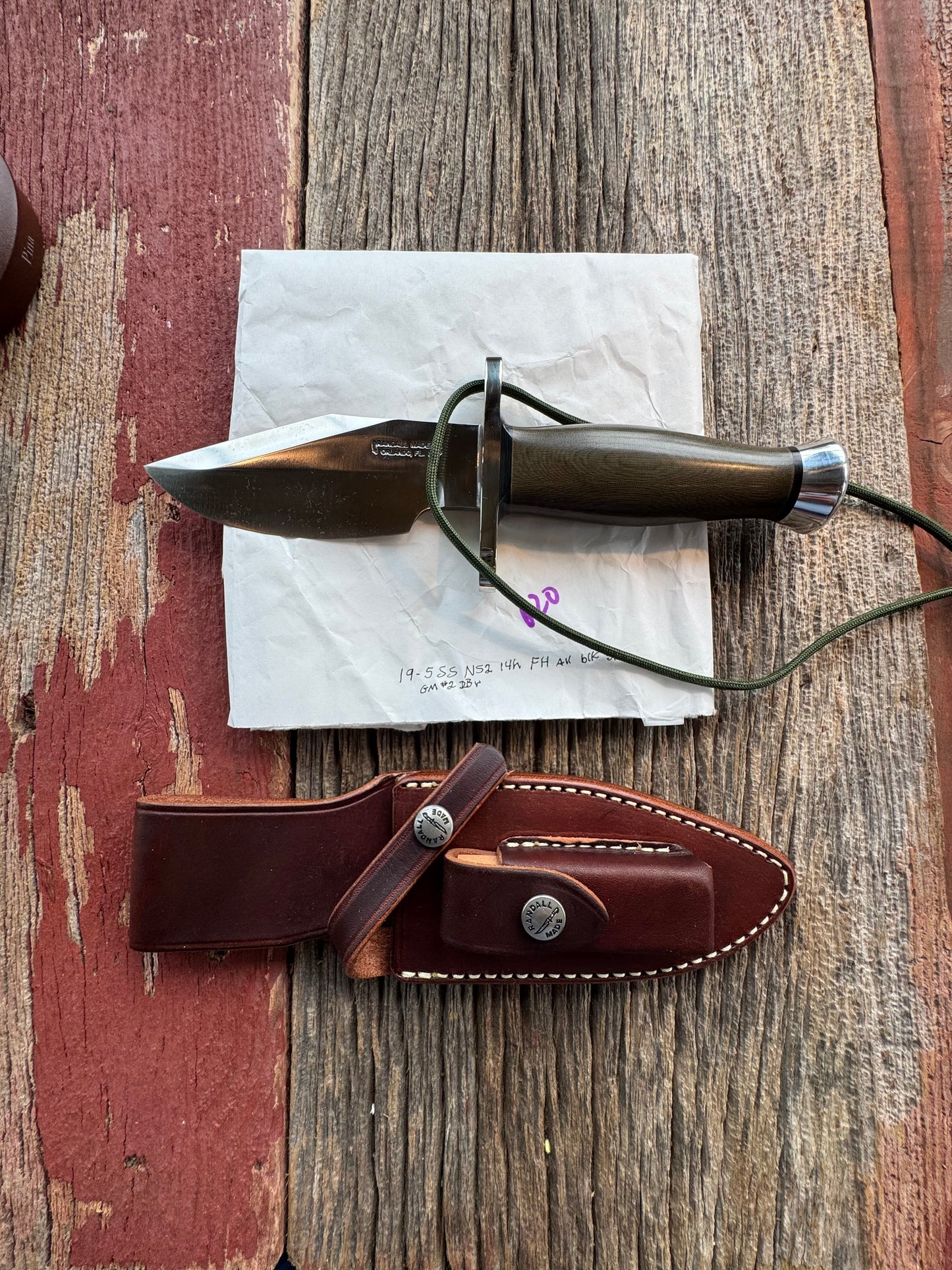New in Paper Randall Model 19-5 Bushmaster with an Green Micarta handle. SS blade, Nickel silver single hilt. Lanyard. Brown leather sheath.