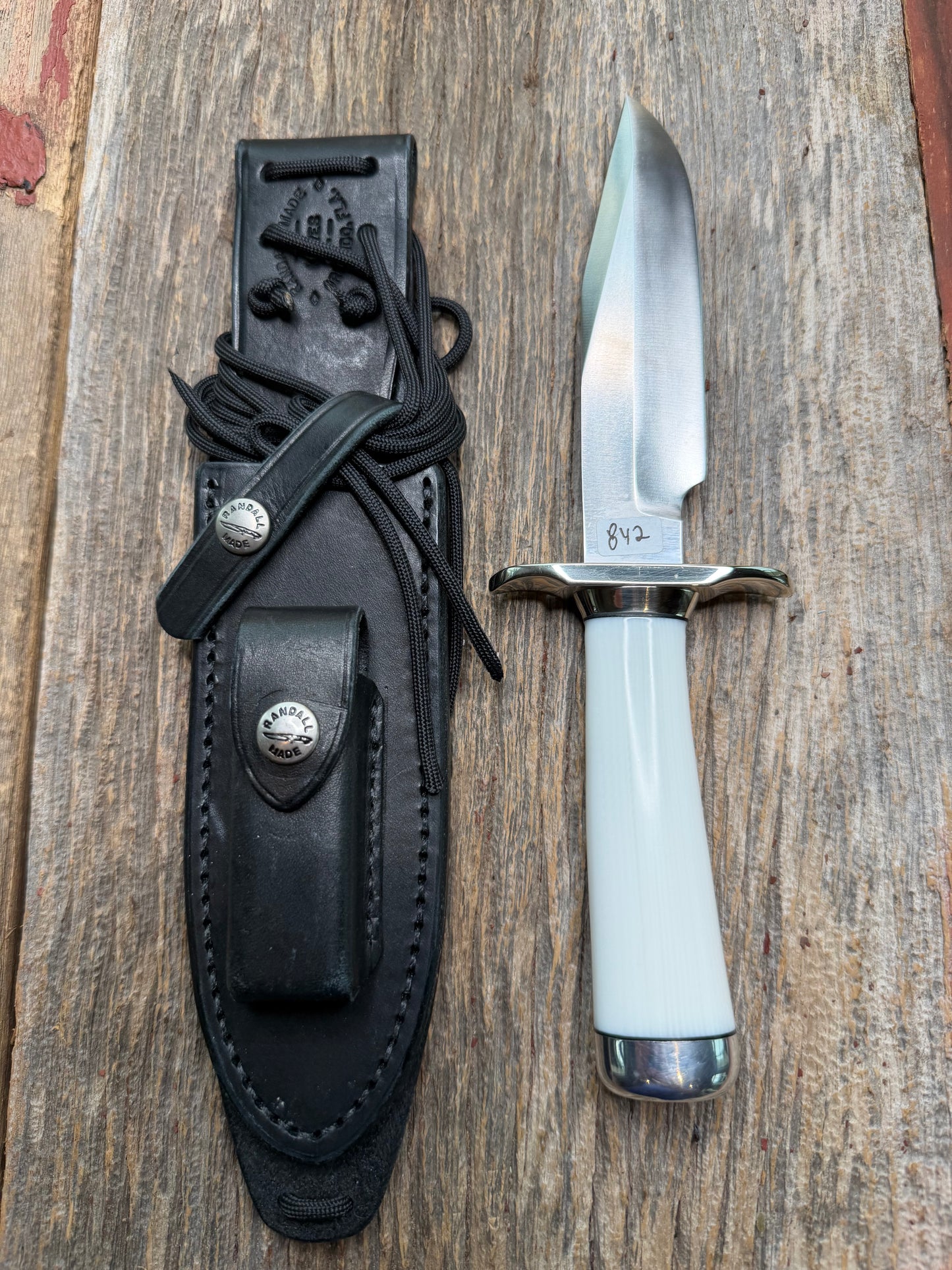 Randall Model 15 with a White Ivorite handle. Stainless steel blade, Nickel silver hilt and collar. Upgraded Black leather sheath.  Roundsd Aluminum butt cap.