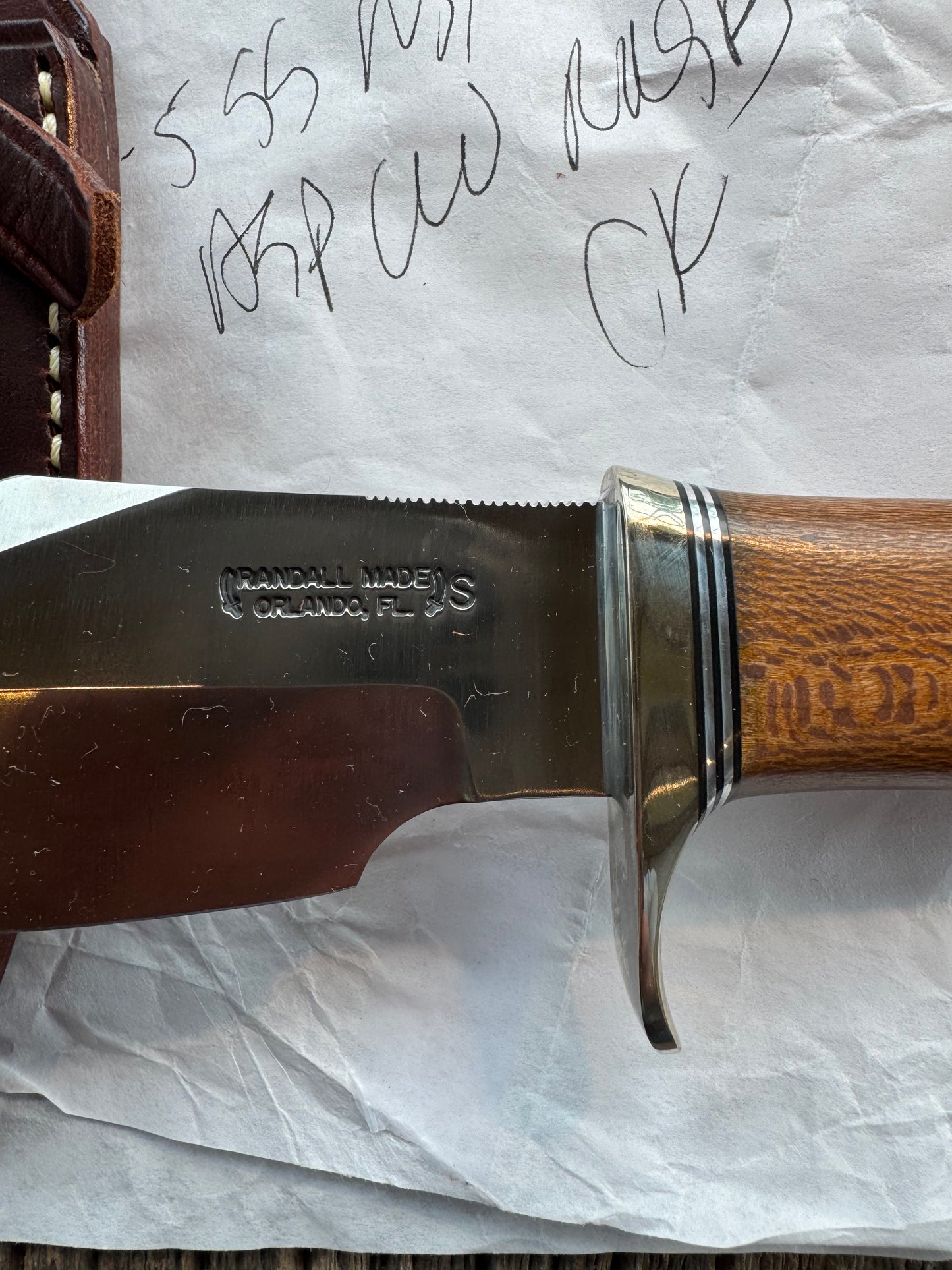 New in Paper Randall Model 19-5 Bushmaster with an Oak handle. SS blade, Nickel silver single hilt. Lanyard. Brown leather sheath.