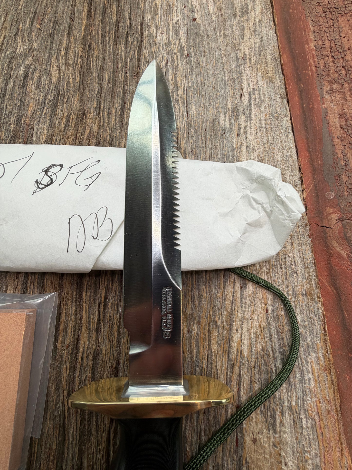 New in Paper Randall Model 16-7 Diver with a Black Micarta handle, Single finger grip , SS blade, Brass hilt, Sawteeth, Lanyard, Brown leather waxed sheath.
