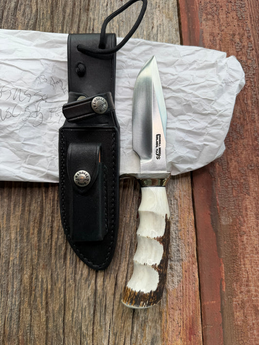 New in paper Randall Model 23 Game Master in Stag with finger grooves. Stainless steel blade, Nickel silver Collar and Brown leather sheath.