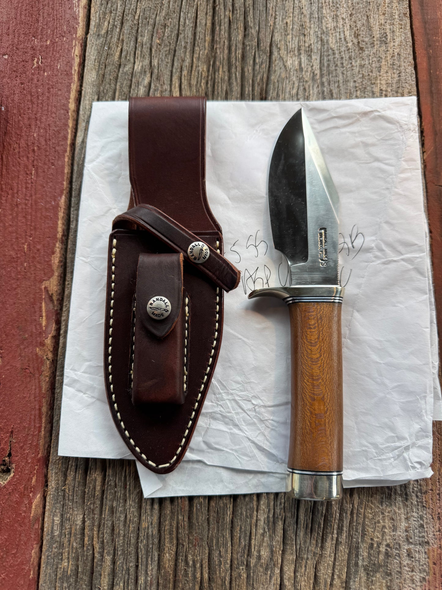 New in Paper Randall Model 19-5 Bushmaster with an Oak handle. SS blade, Nickel silver single hilt. Lanyard. Brown leather sheath.