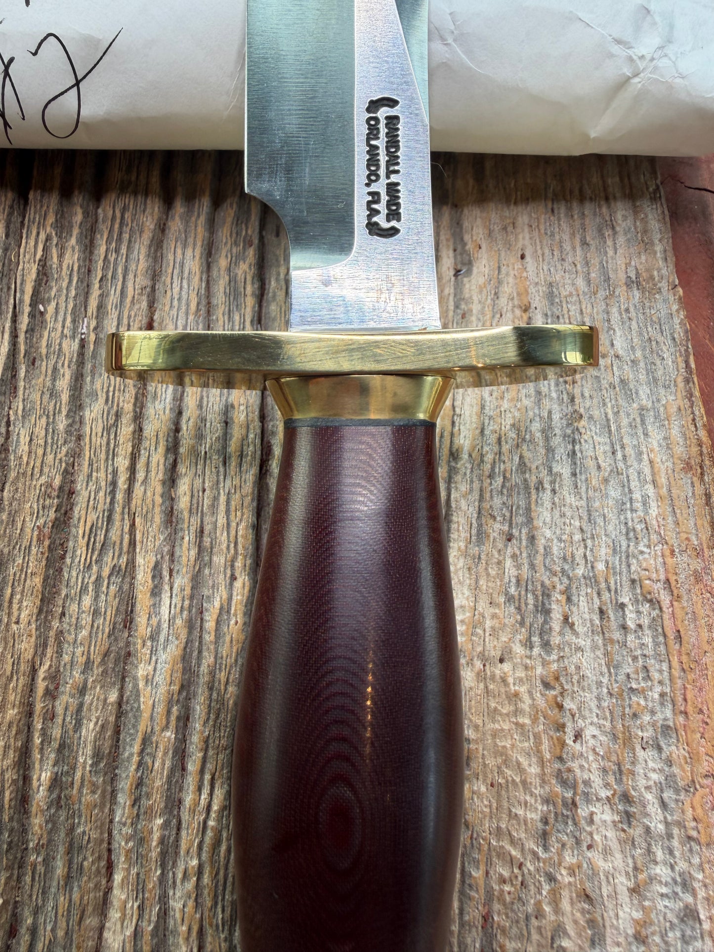 New in Paper Randall Model 12-6 Little Bear with a Maroon Micarta handle. Brass Hilt  and Brass collar Carbon steel, natural end.