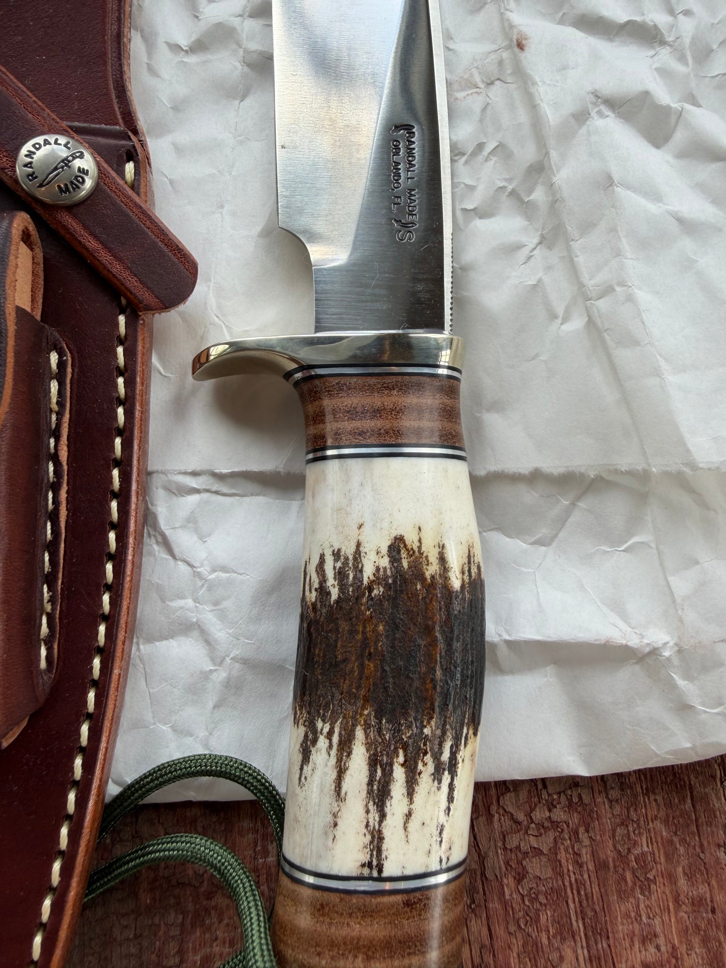 New in paper Randall Knife Model 25-6 Trapper in Stag Leather Handle Stainless Blade, nickel silver hilt , wrist thong.