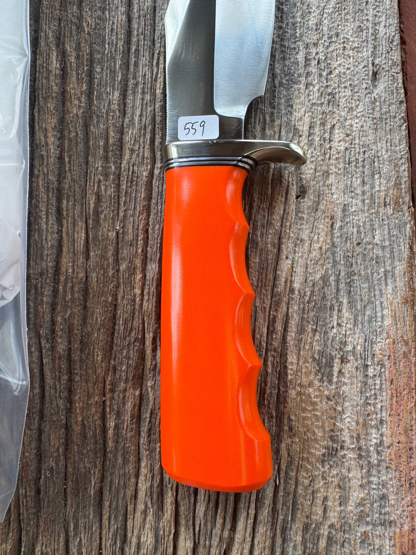 New in paper Randall Model 19-5 with a nice piece of customer supplied Orange G10 with finger grooves. Stainless Steel, Nickel Silver Hilt and a raw natural end.