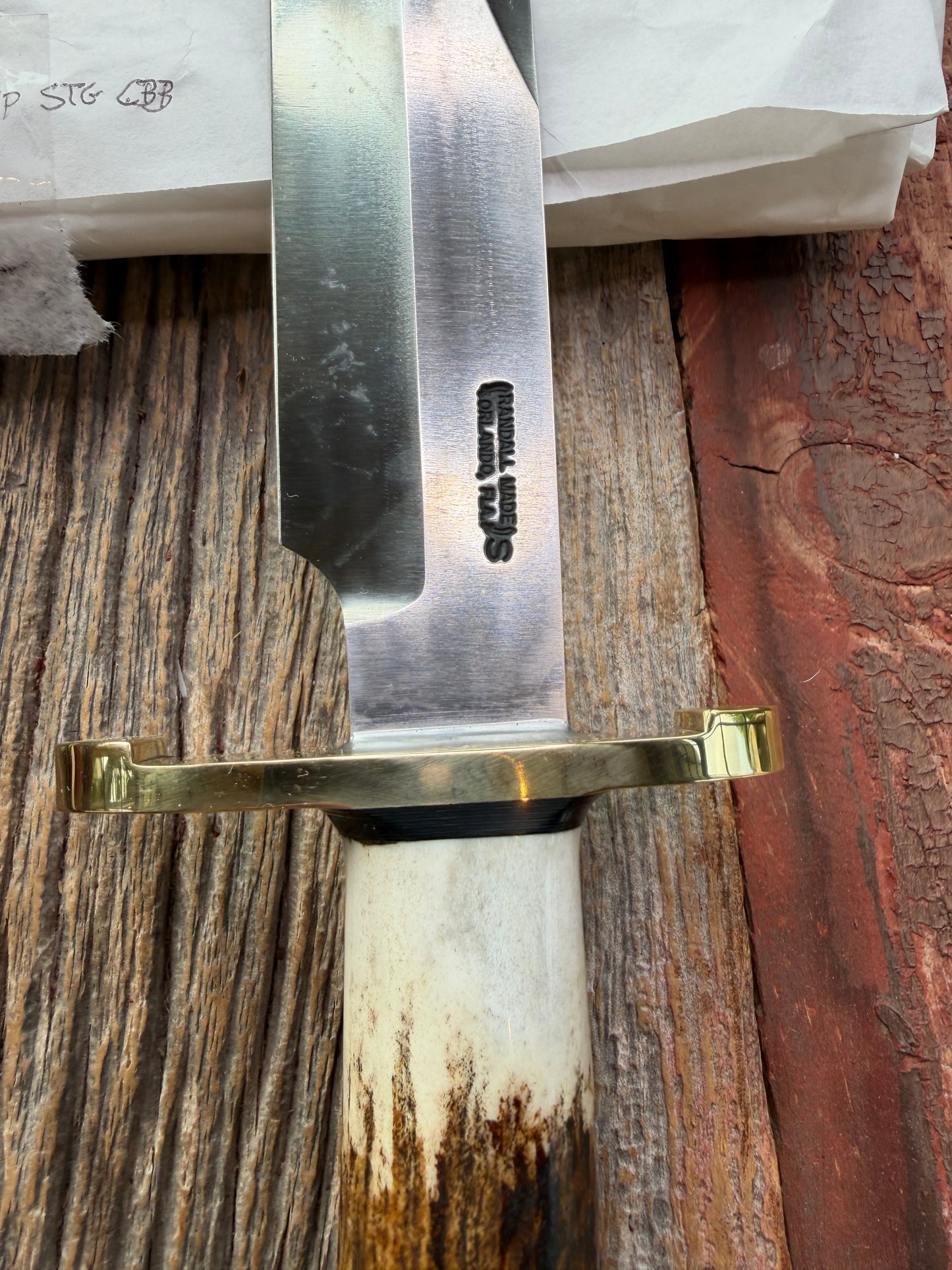 New in paper fresh from the Shop. Randall Knife Model 14-7.5 Big. Nice piece of Stag, Gorgeous Brass Lugged hilt and brass crows beak butt cap. Single black spacer. Stainless steel.