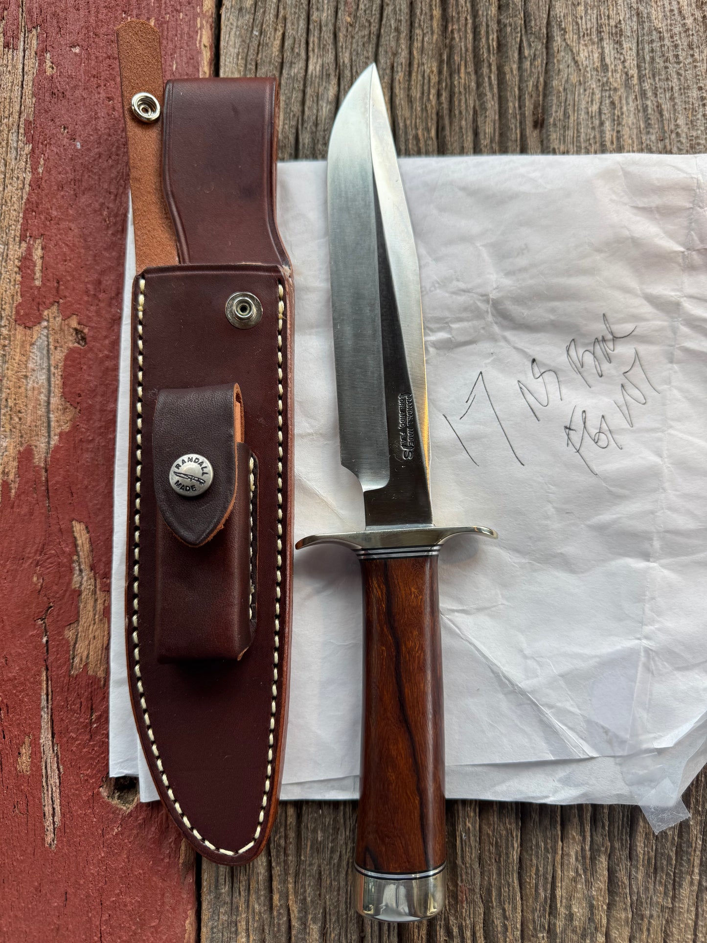 New in Paper Randall Model 1-7 Stainless steel blade, Nickel silver hilt and butt cap. Brown leather sheath. Burl wood handle.