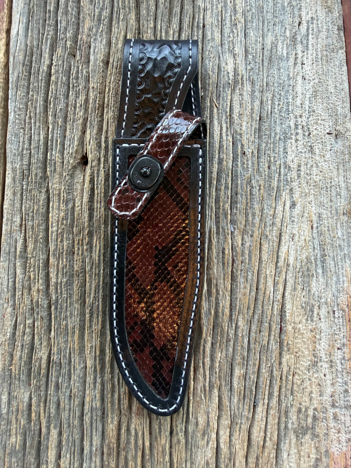 New Randall Model 1-6 Sheath in Exotic Brown Python Snake skin on black leather from Treeman with a black Canteen snap. Hand tooled belt loop. Deviated white stitching. Killer sheath.