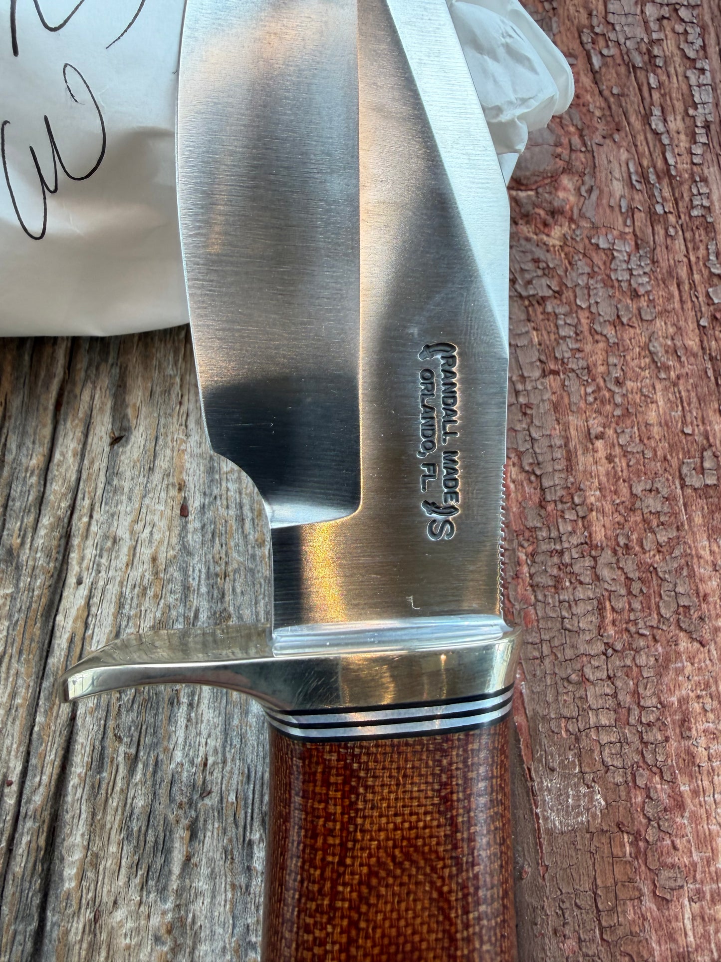 New in Paper Randall Model 19-5 Bushmaster with an Brown Micarta handle. SS blade, Nickel silver single hilt. Lanyard. Brown leather sheath.