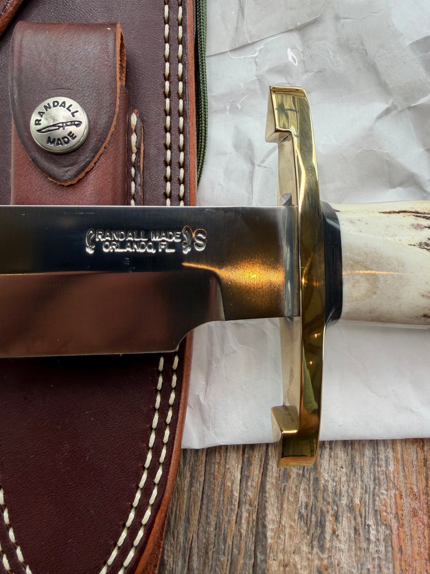 New in paper fresh from the Shop. Randall Knife Model 14-7.5 Big. Nice piece of Stag, Gorgeous Brass Lugged hilt and brass crows beak butt cap. Single black spacer. Stainless steel.