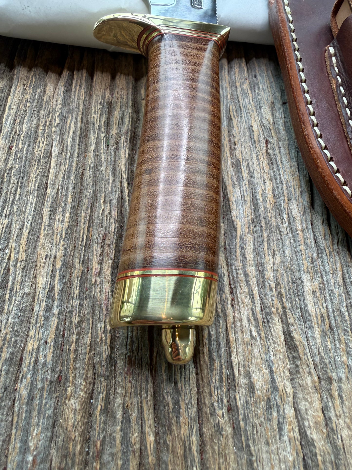 New in Paper Randall Model 19-5 Bushmaster with a Leather handle. Carbon blade, Brass single hilt. Brown leather sheath.
