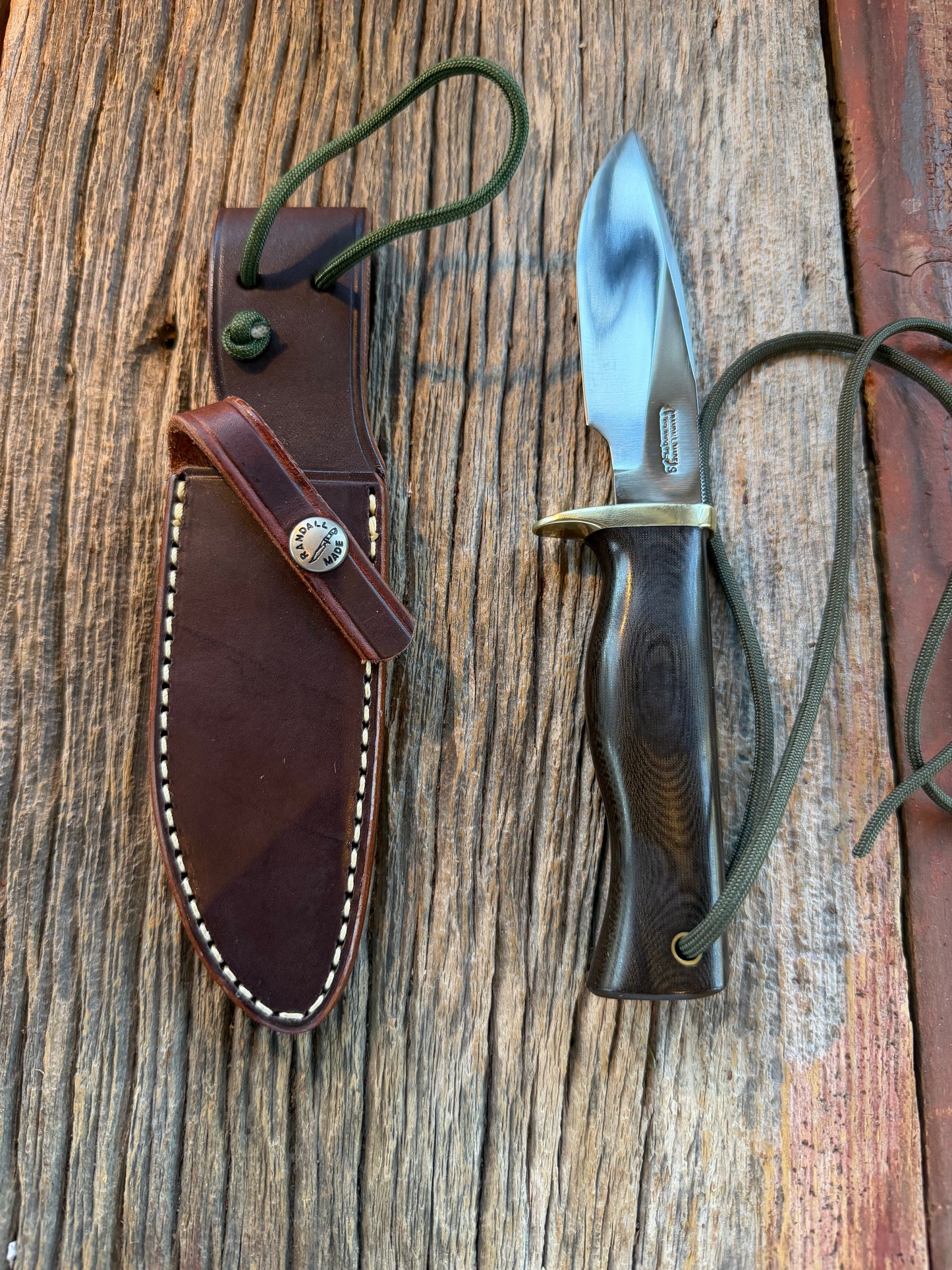 Nice Randall Model 28 Woodsman in Black Micarta. SS blade, brass single hilt. Lanyard. Brown leather sheath.
