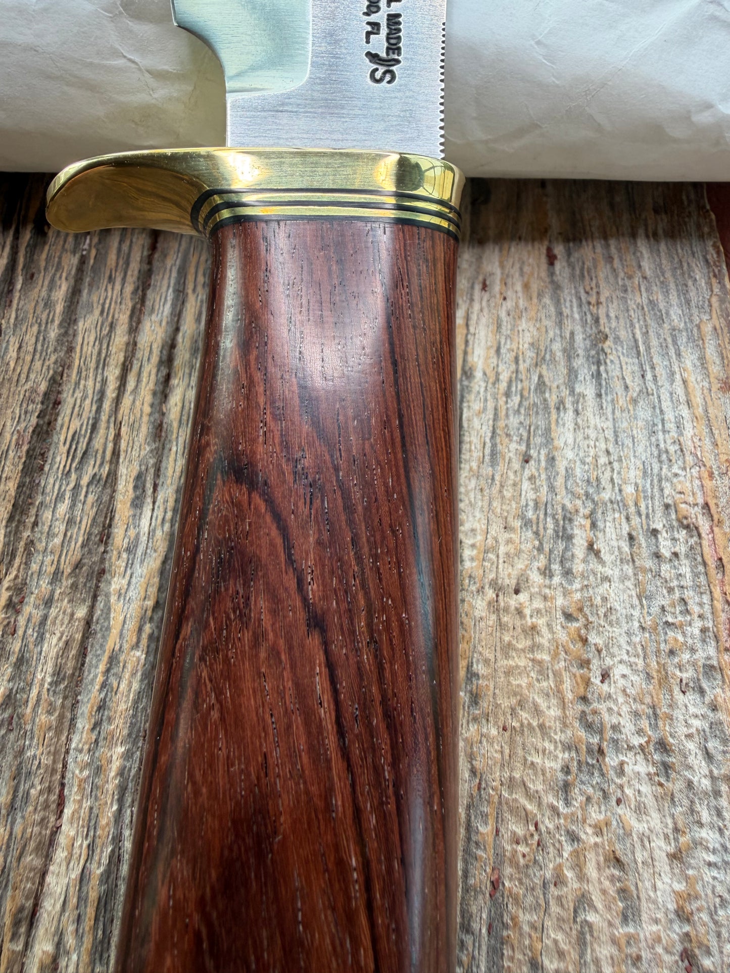 New in Paper Randall Model 19-5 with a really nice grainy piece of Ironwood. brass single Hilt , Stainless steel, Lanyard and Brass plate.
