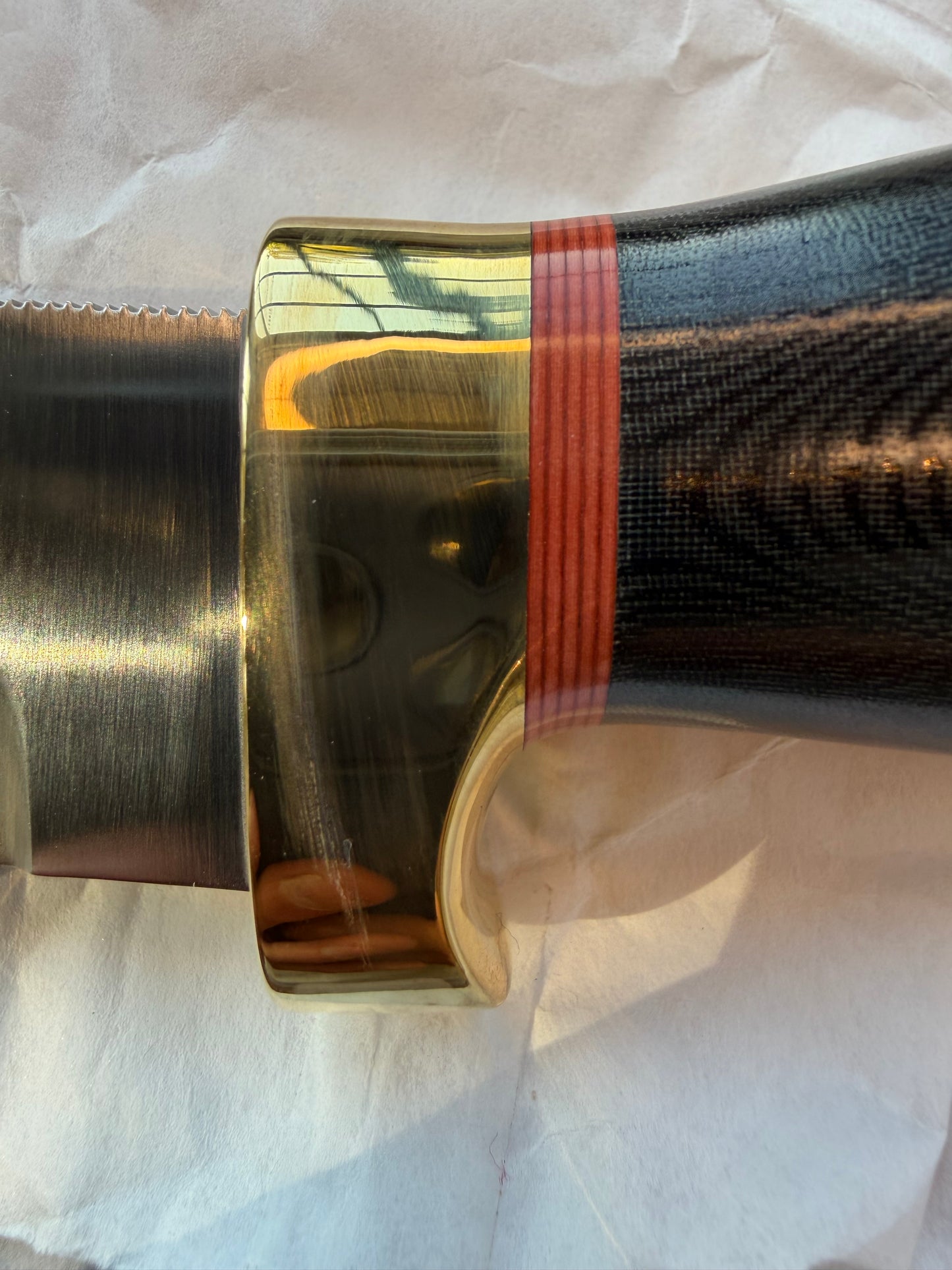 New in Paper Randall Chef’s Knife. Black Micarta in Brass with red spacers. Natural end, stainless steel blade and a lanyard.