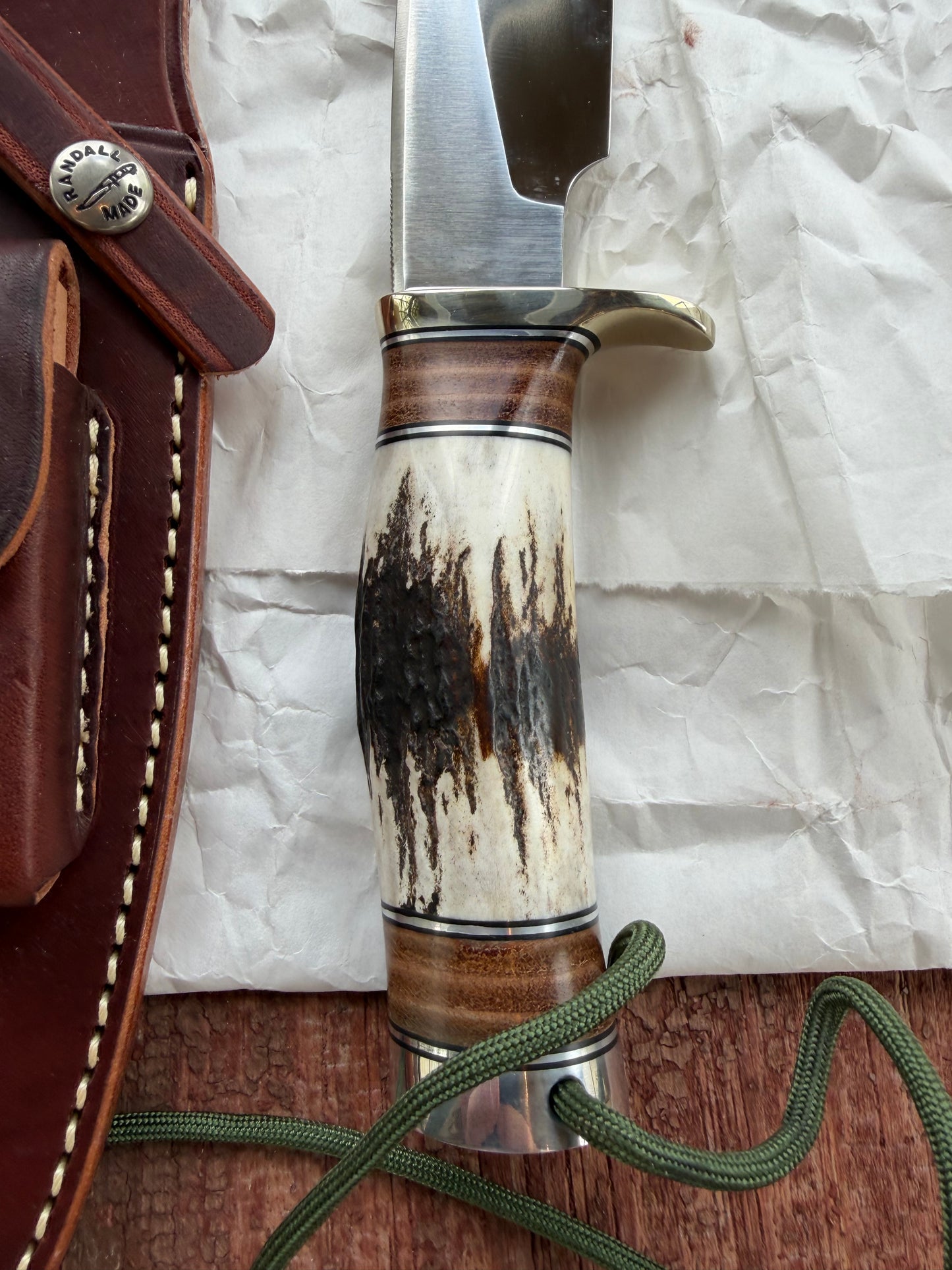 New in paper Randall Knife Model 25-6 Trapper in Stag Leather Handle Stainless Blade, nickel silver hilt , wrist thong.