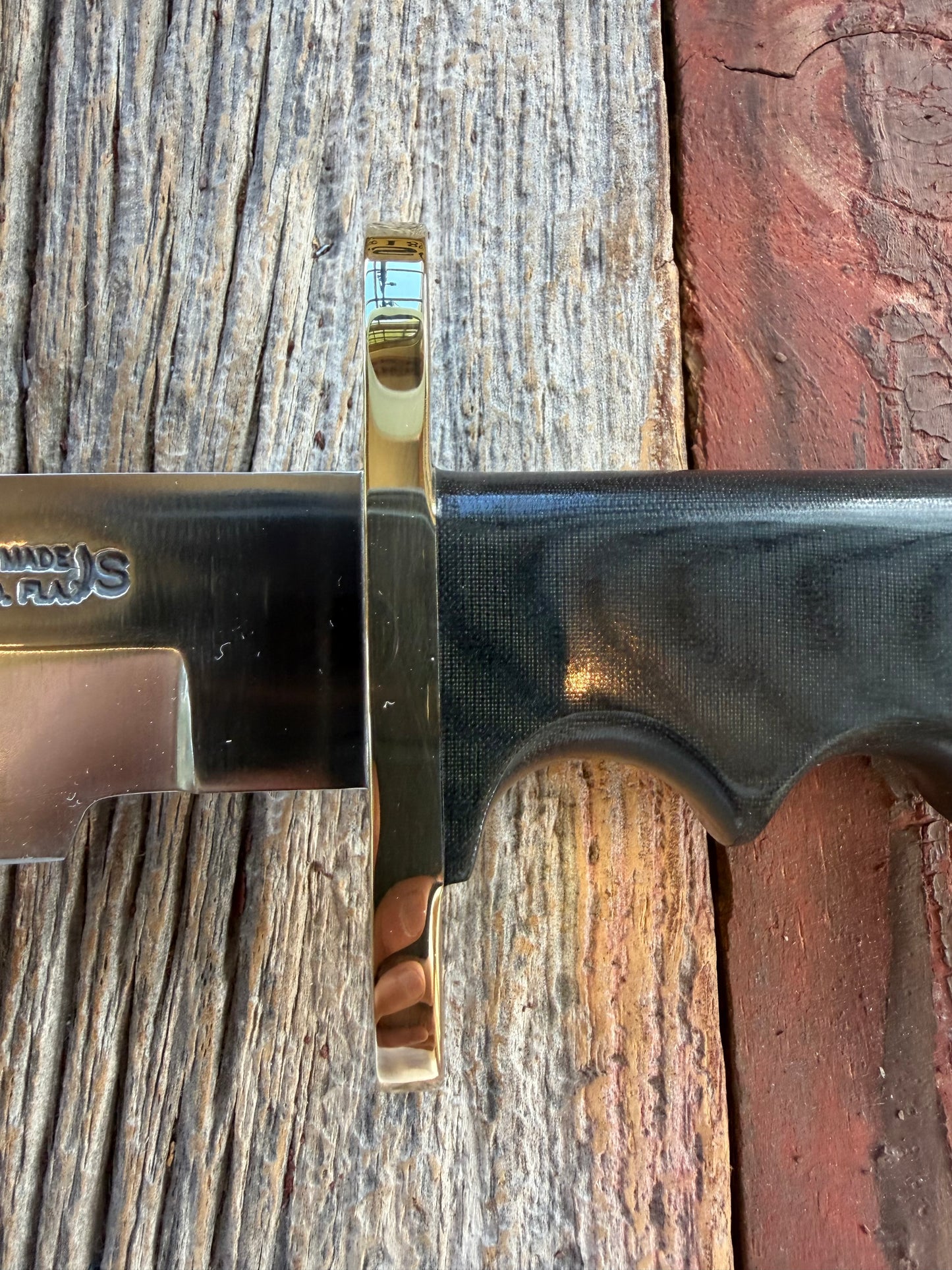 Randall Model 14-7.5 with a Black Micarta finger grooved handle. Stainless steel blade, Brass double hilt brown leather sheath.