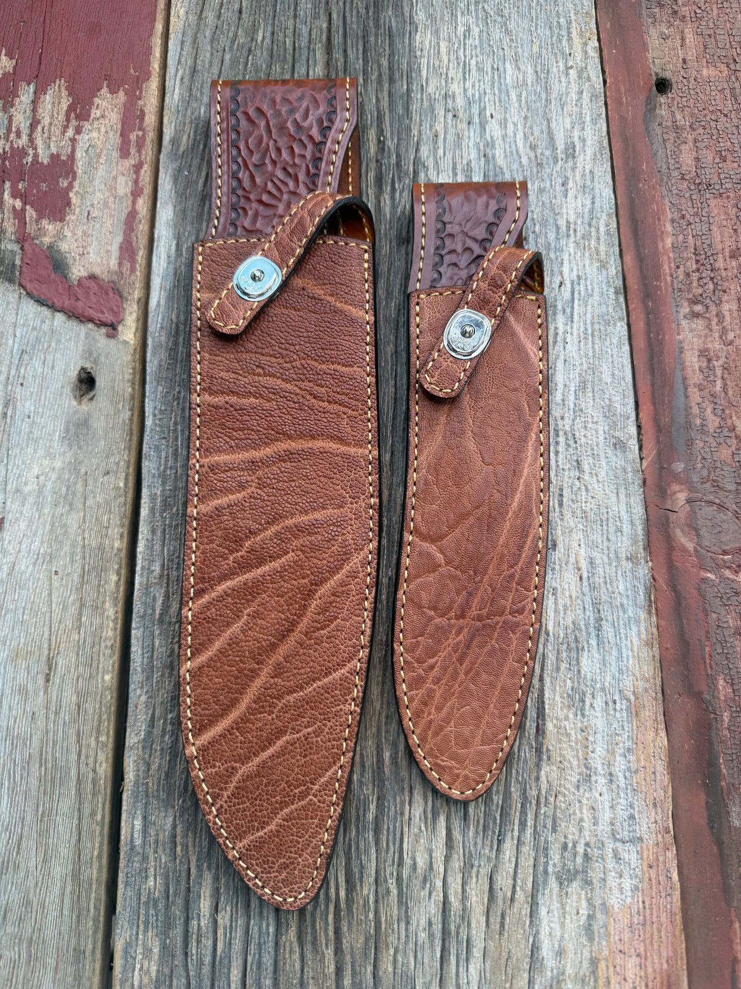 New Randall Model 12-11 Large Sasquatch and 12-8 Small Sasquatch Sheaths in Exotic thick and textured Rust colored Elephant hide on brown leather from Treeman with silver Canteen snaps. Hand tooled belt loop. Killer sheath. Selling as a pair…